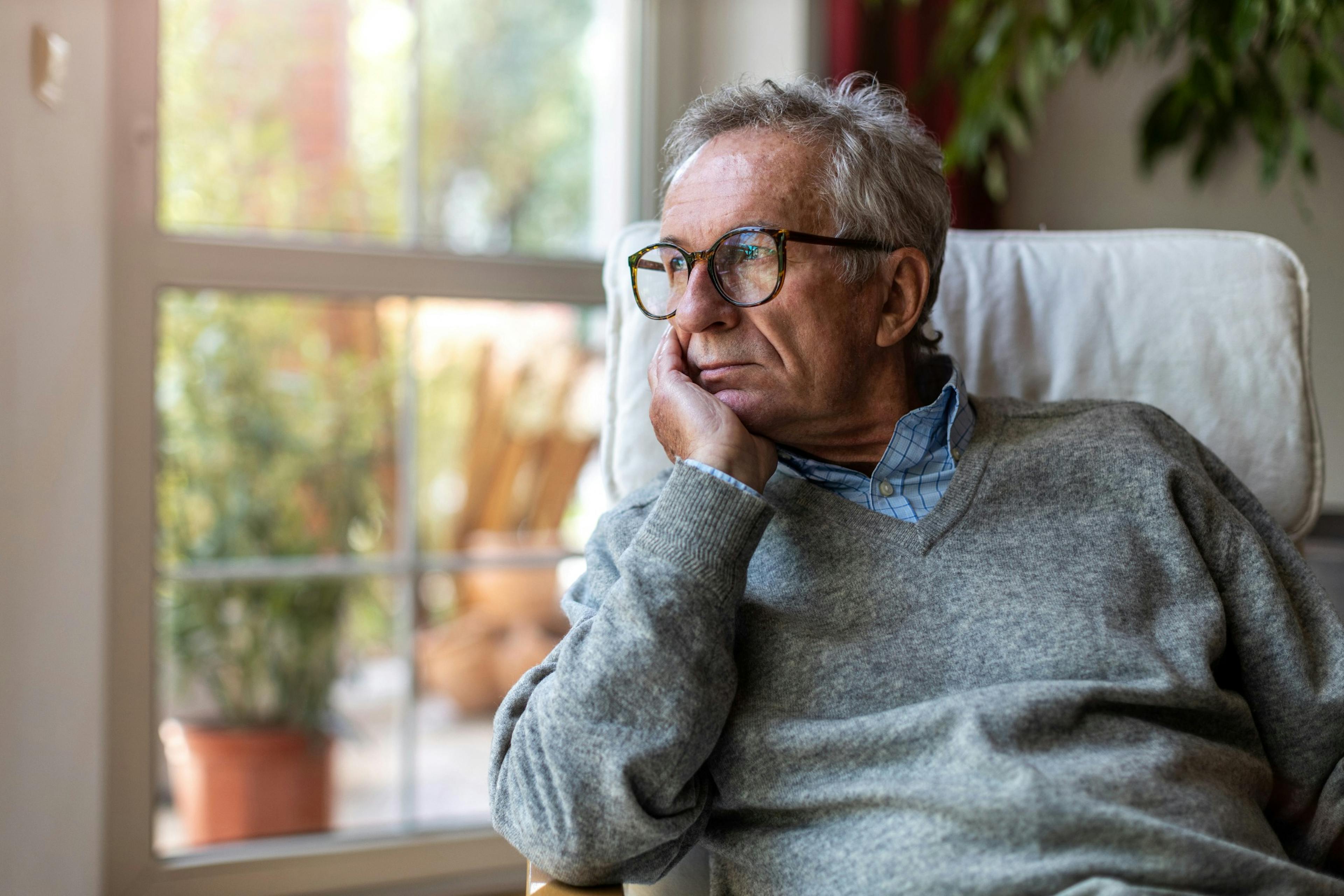 senior man looking out a window