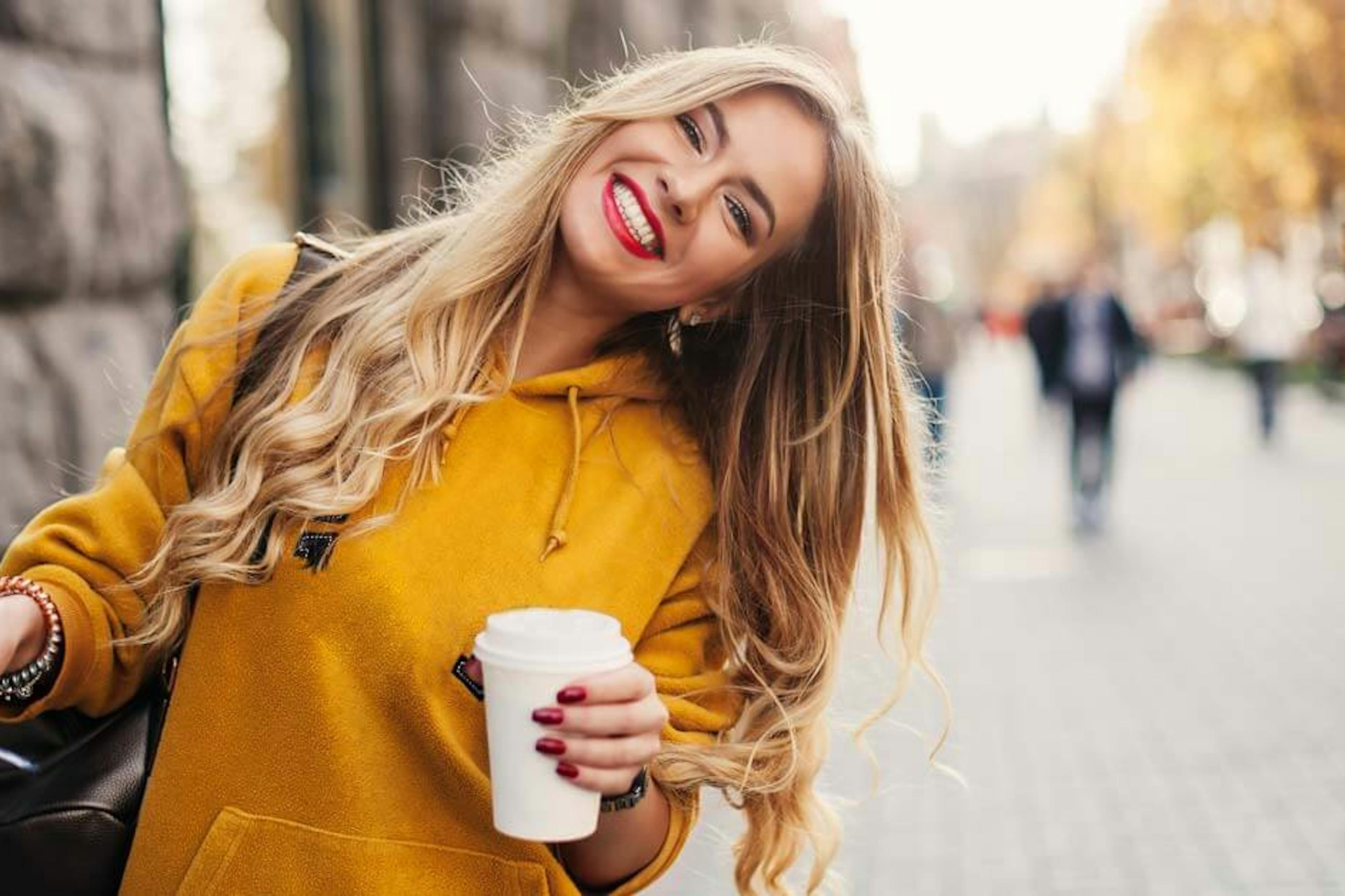 Stylish happy young woman holding glasses