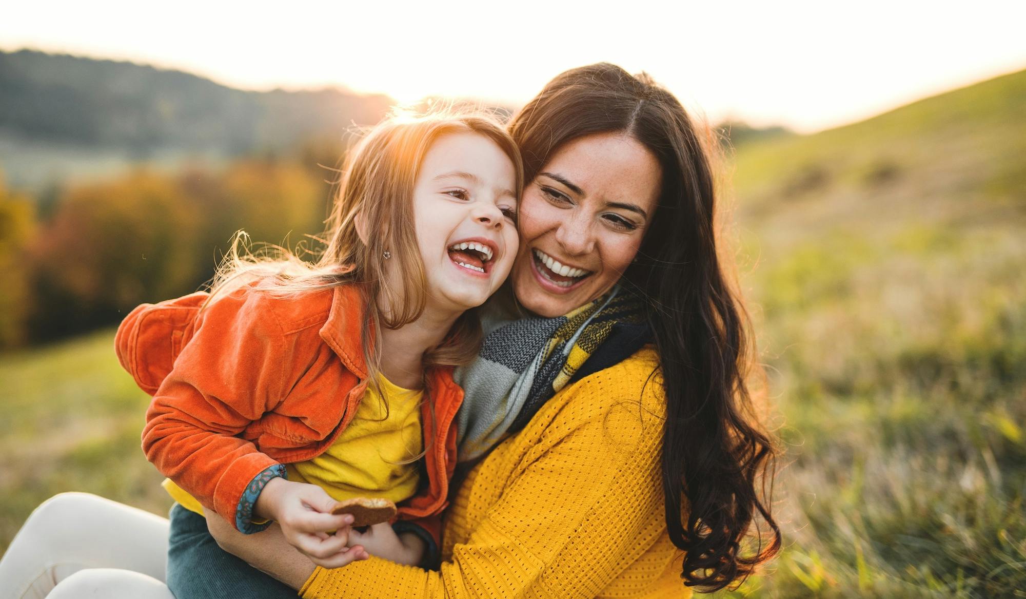 mother and daughter smiling at sunset