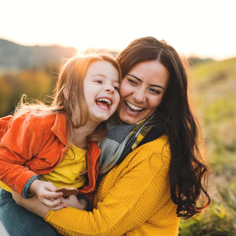 mother and daughter smiling at sunset