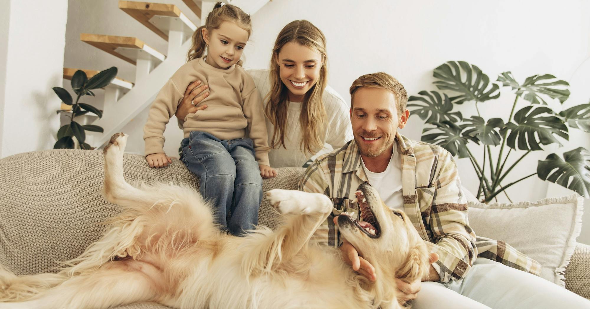 mother, father and daughter with dog at home