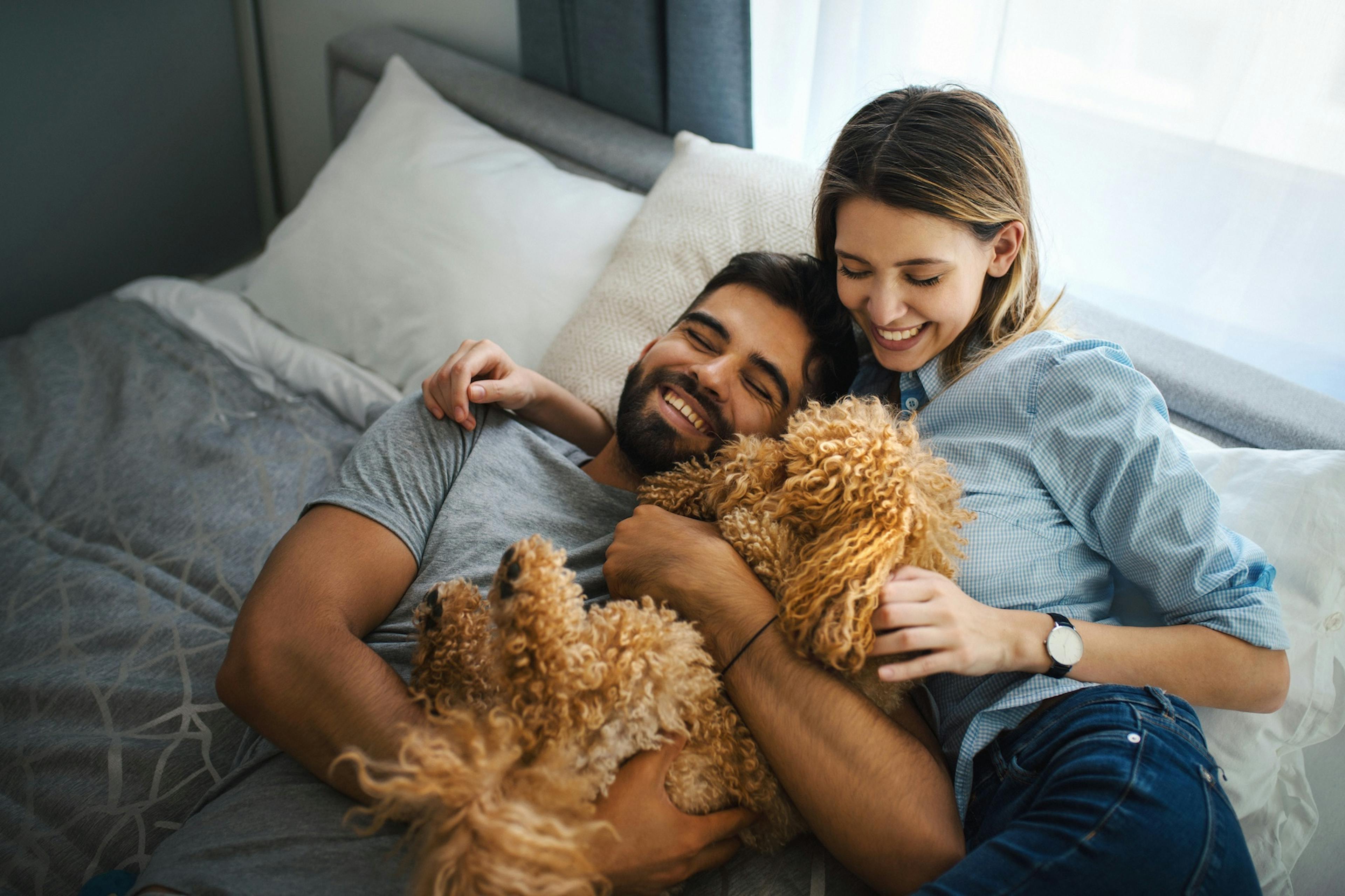 Happy couple at home with a puppy