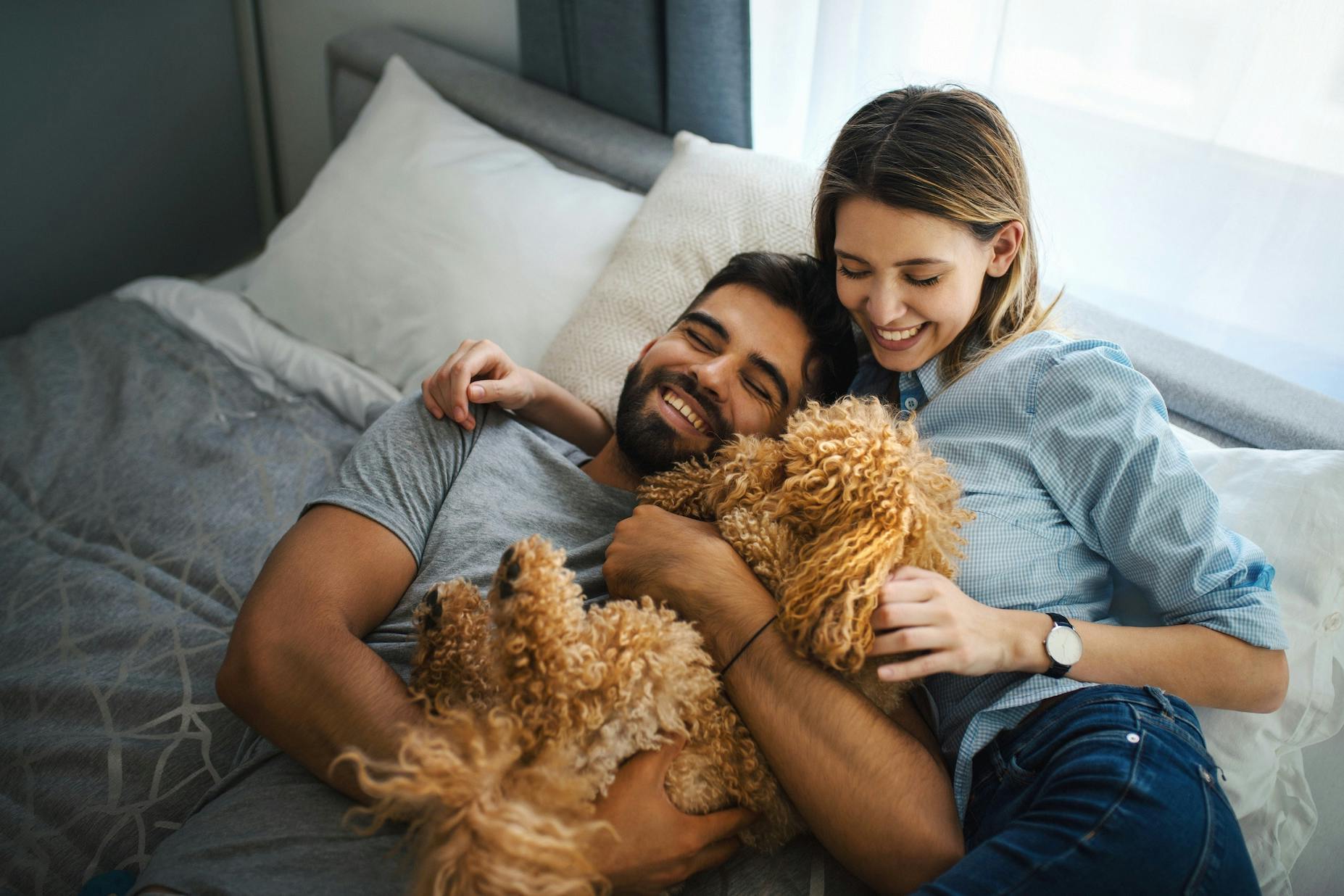 Happy couple at home with a puppy