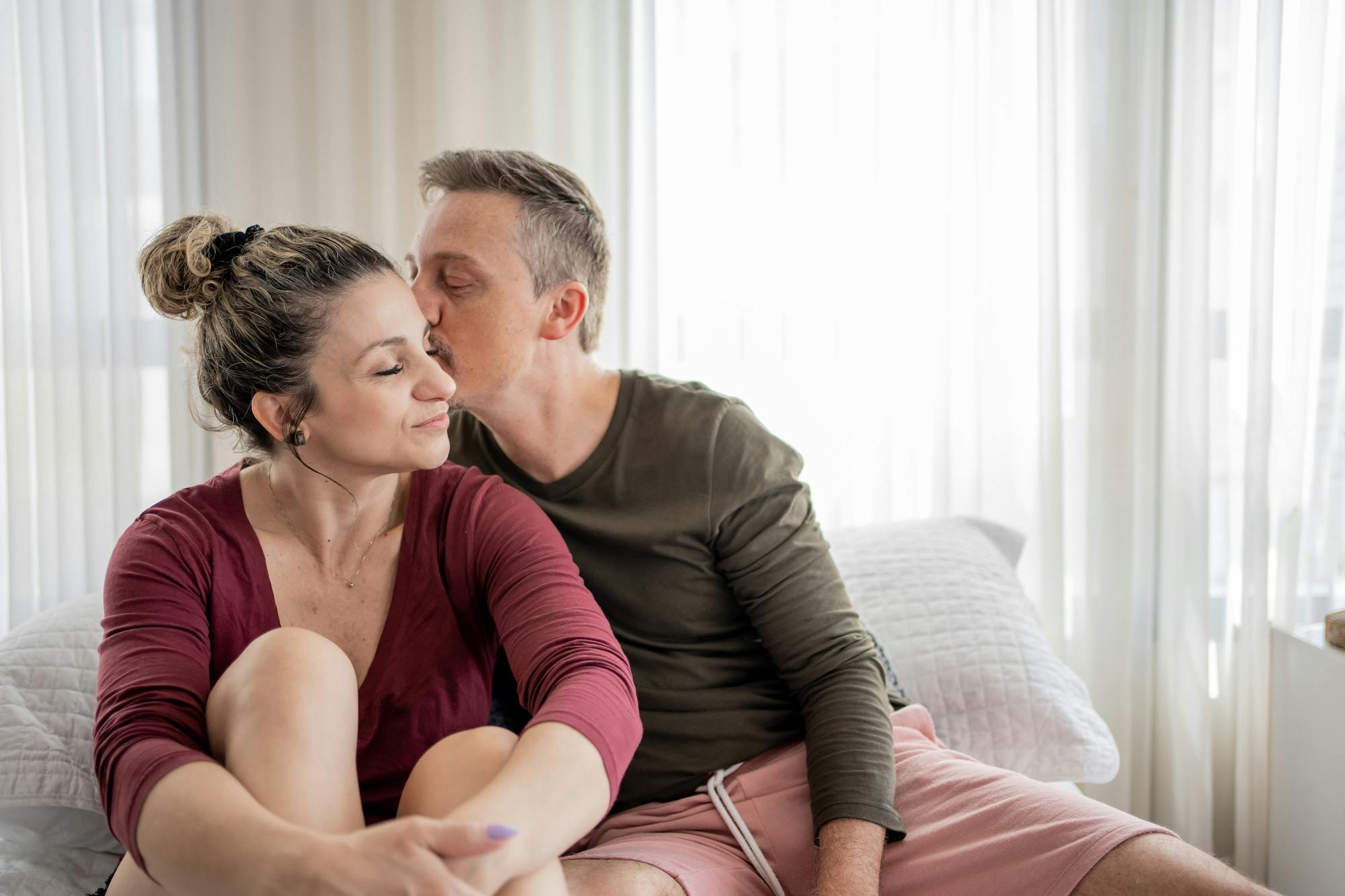 Man kissing his wife in bed