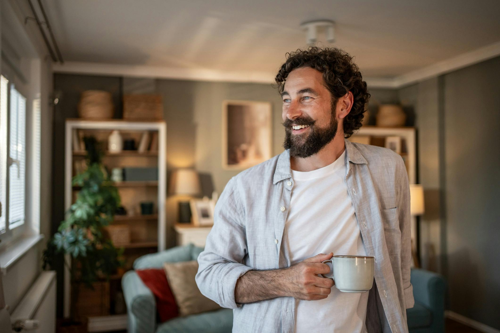Smiling bearded man drinking coffee