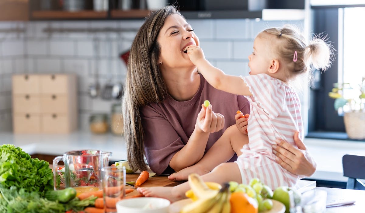 mom and daughter laughing in the kitchen