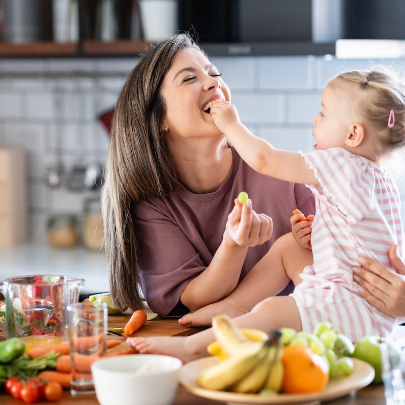 mom and daughter laughing in the kitchen