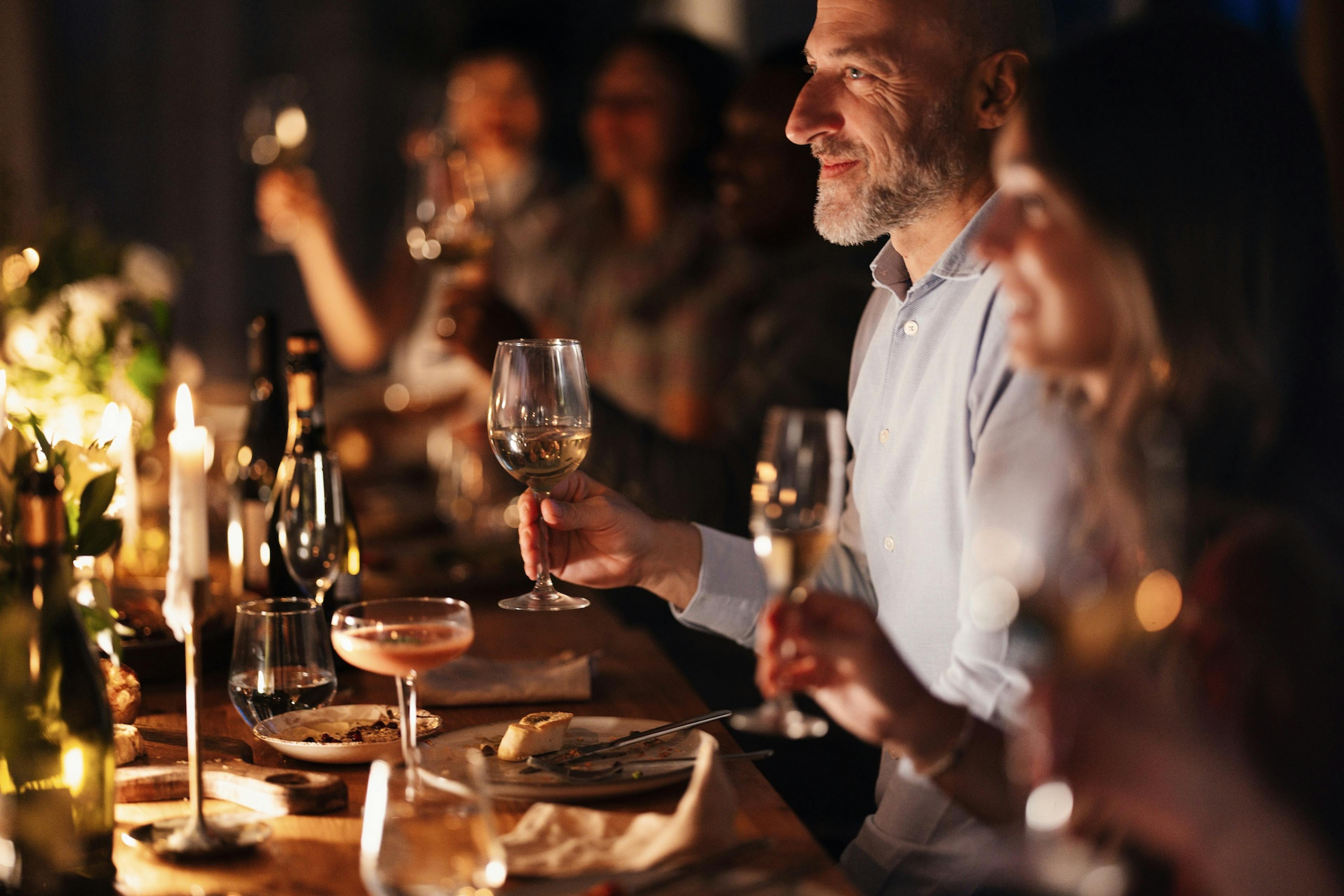 Friends Toasting At A Warm Dinner Party
