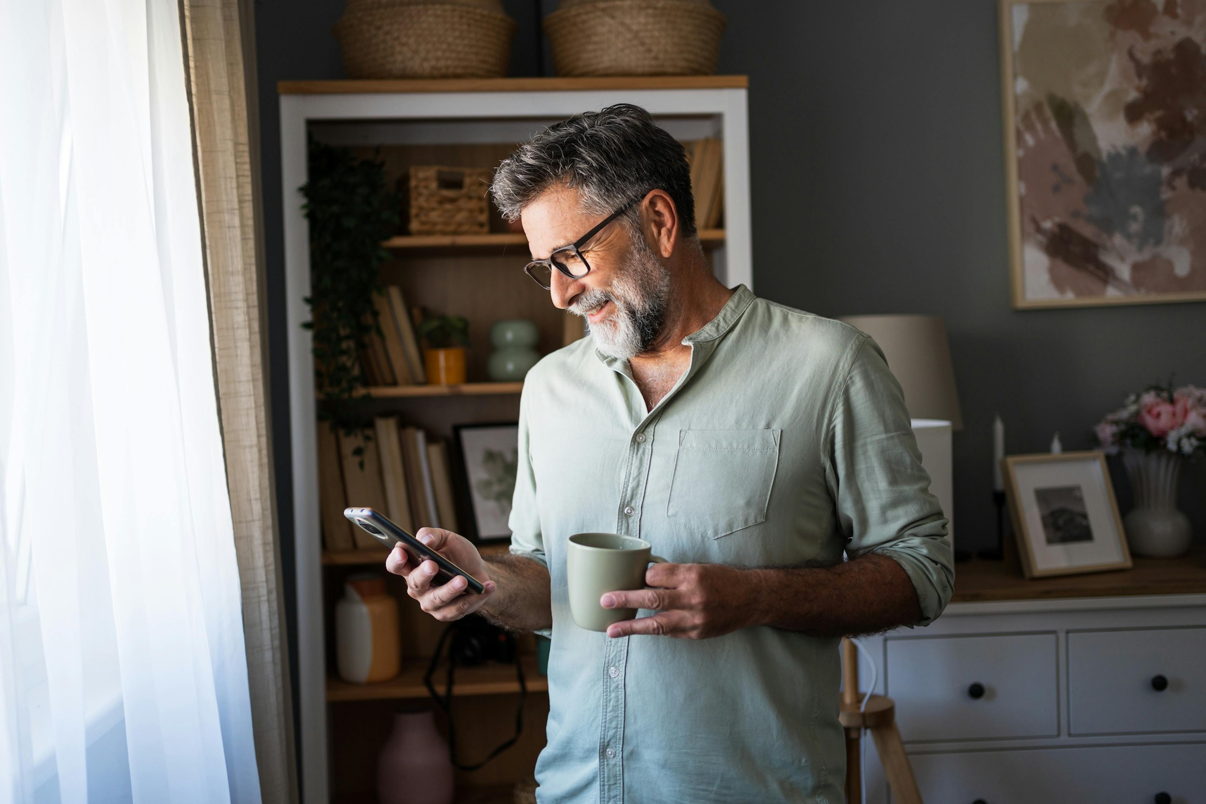 Man drinking coffee and using phone