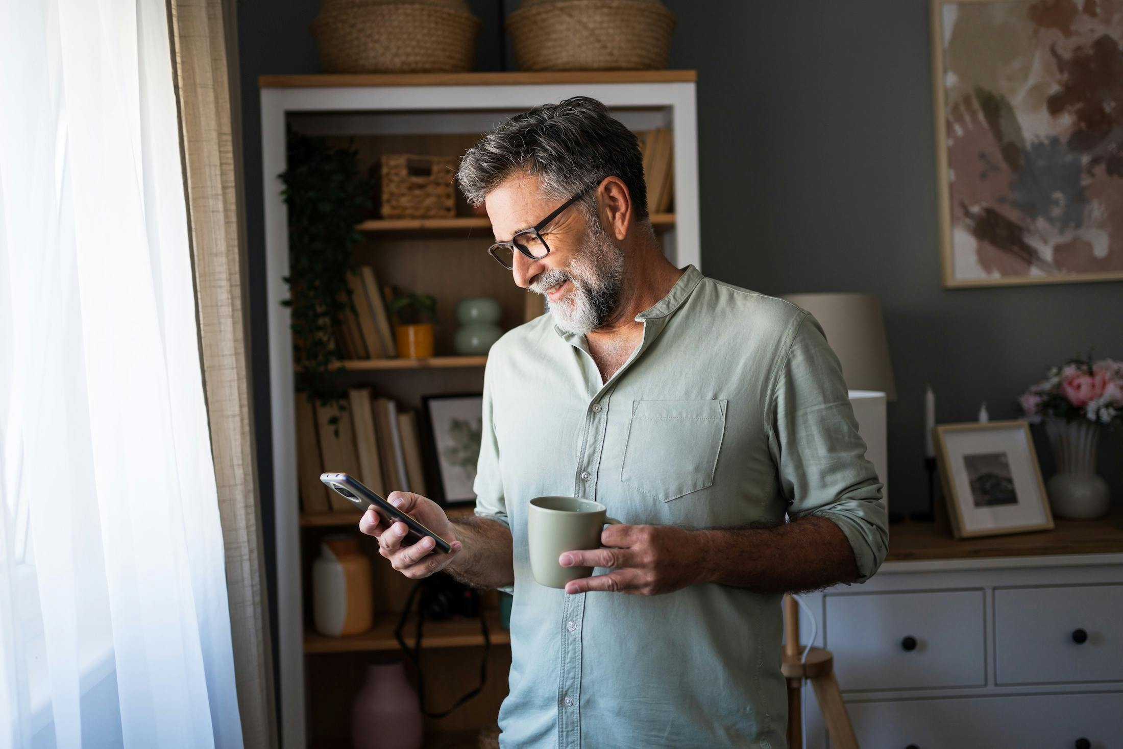 Man drinking coffee and using phone