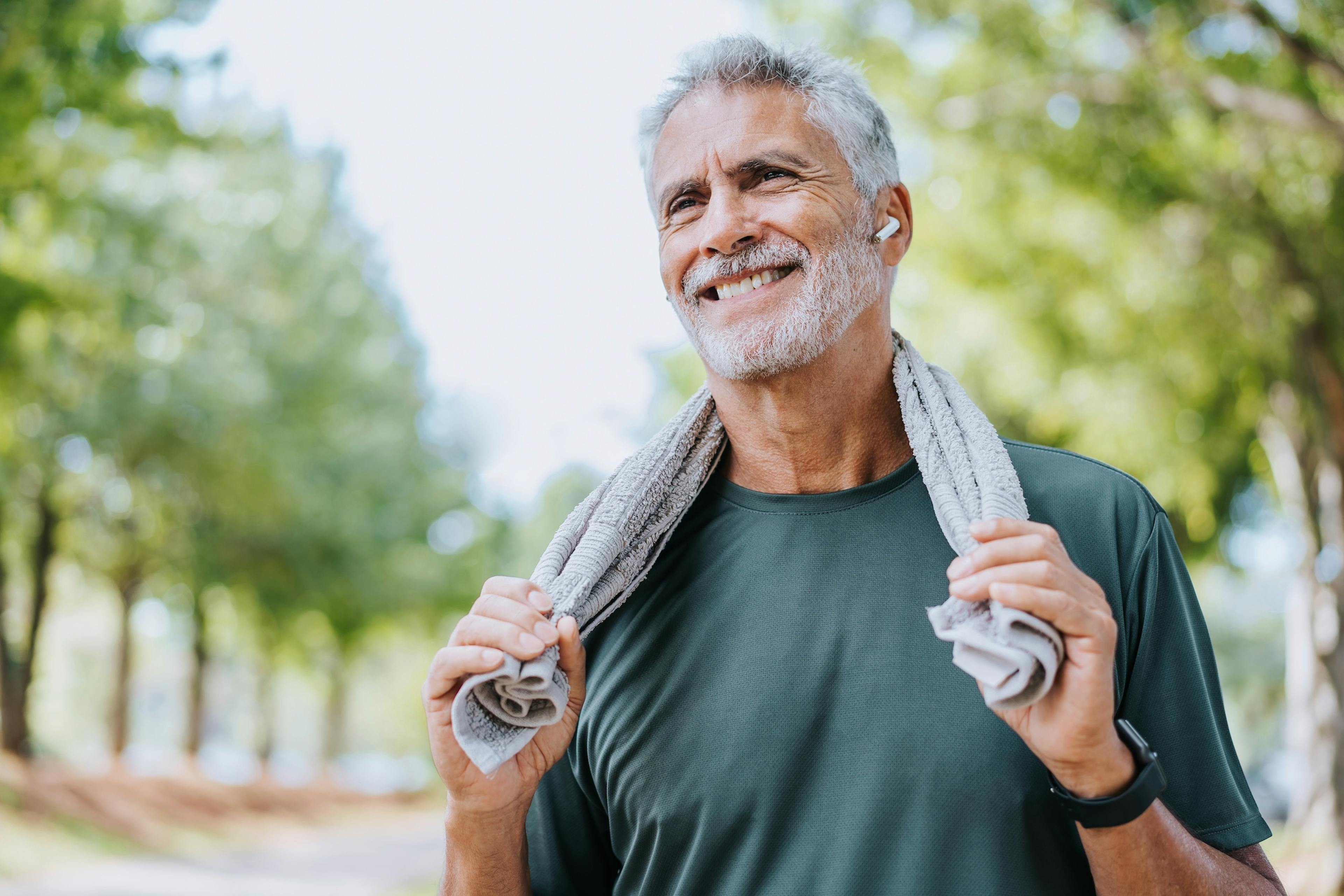 Senior man runner holding towel around neck