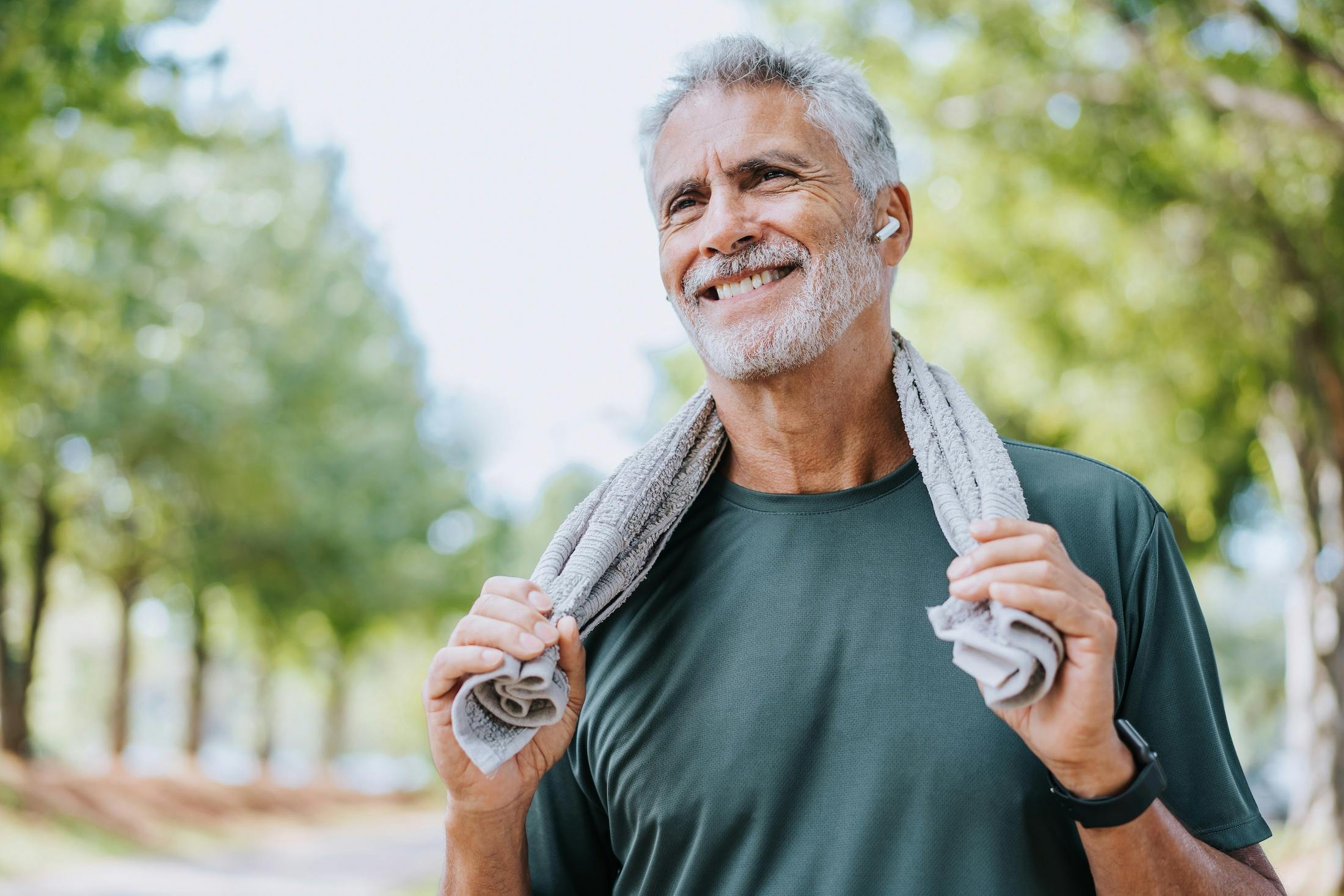 Senior man runner holding towel around neck