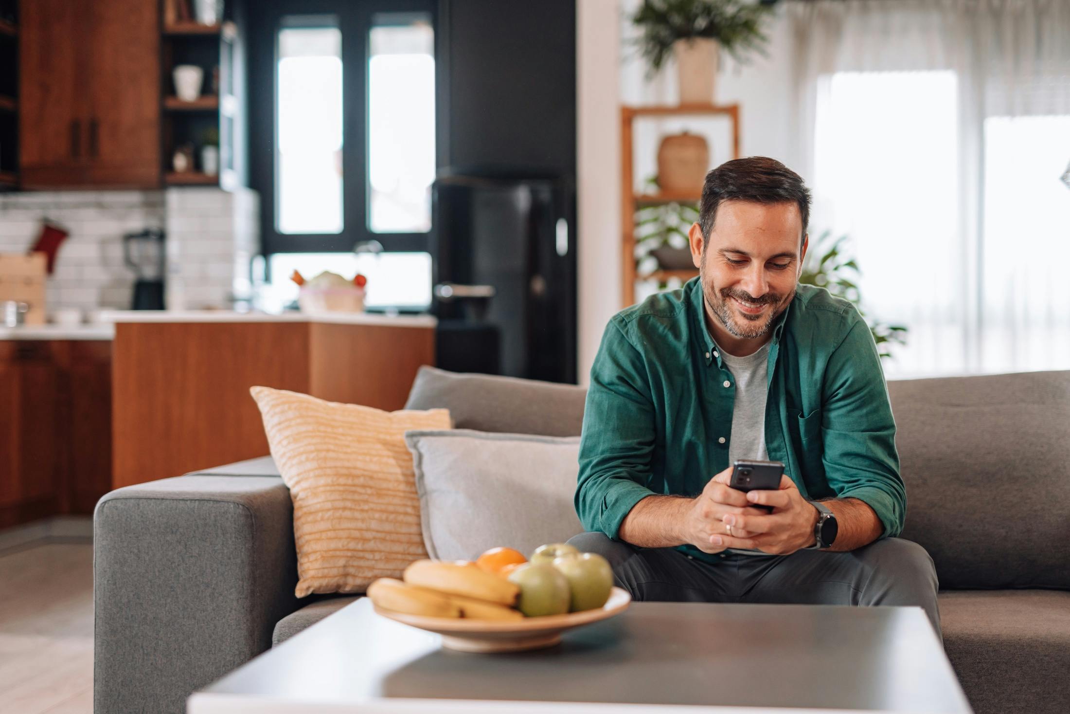 Man relaxing on sofa using smartphone