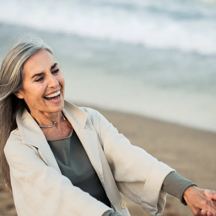 Happy mature woman enjoying a romantic beach vacation