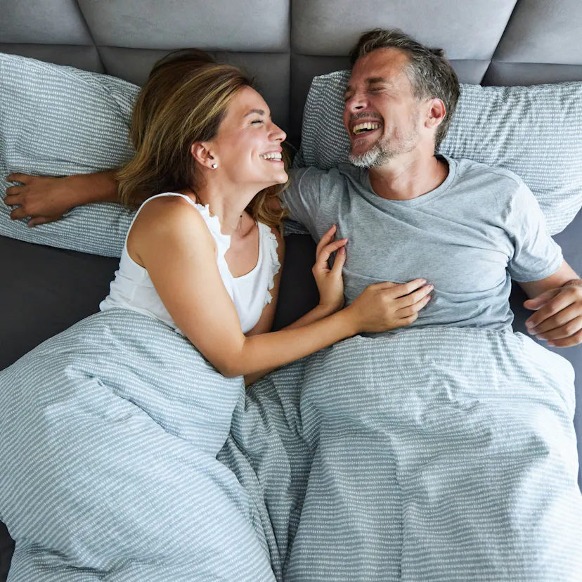 cheerful couple having fun during morning in bed