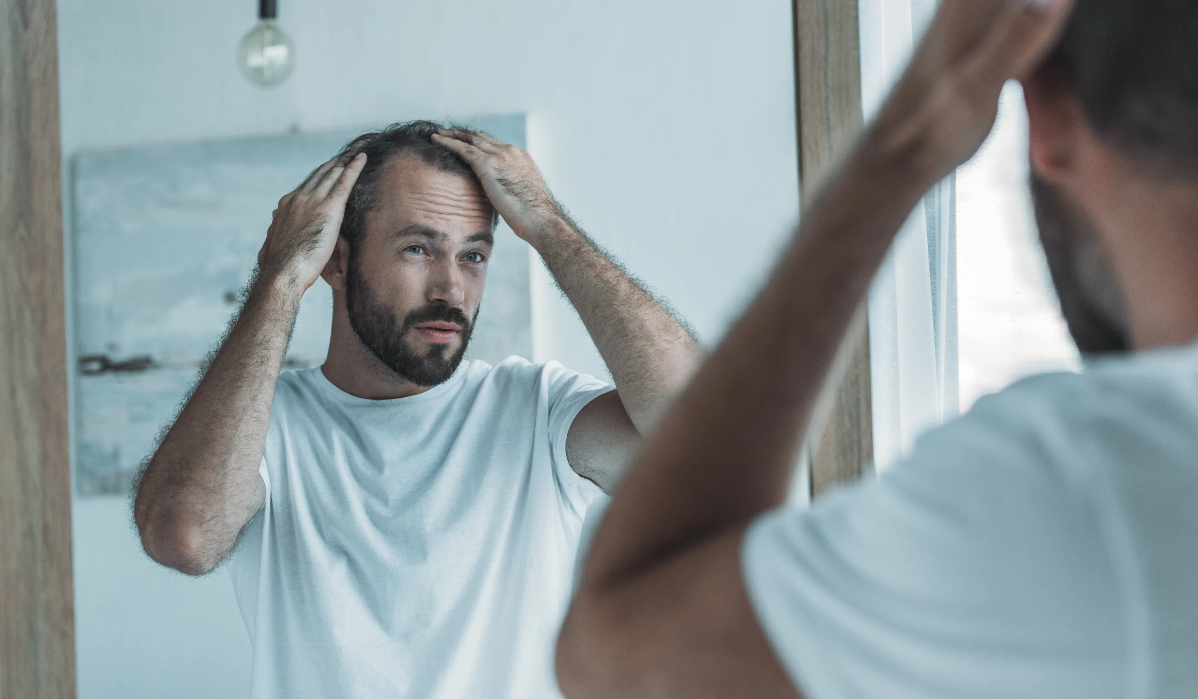 middle-aged man checking for hairloss
