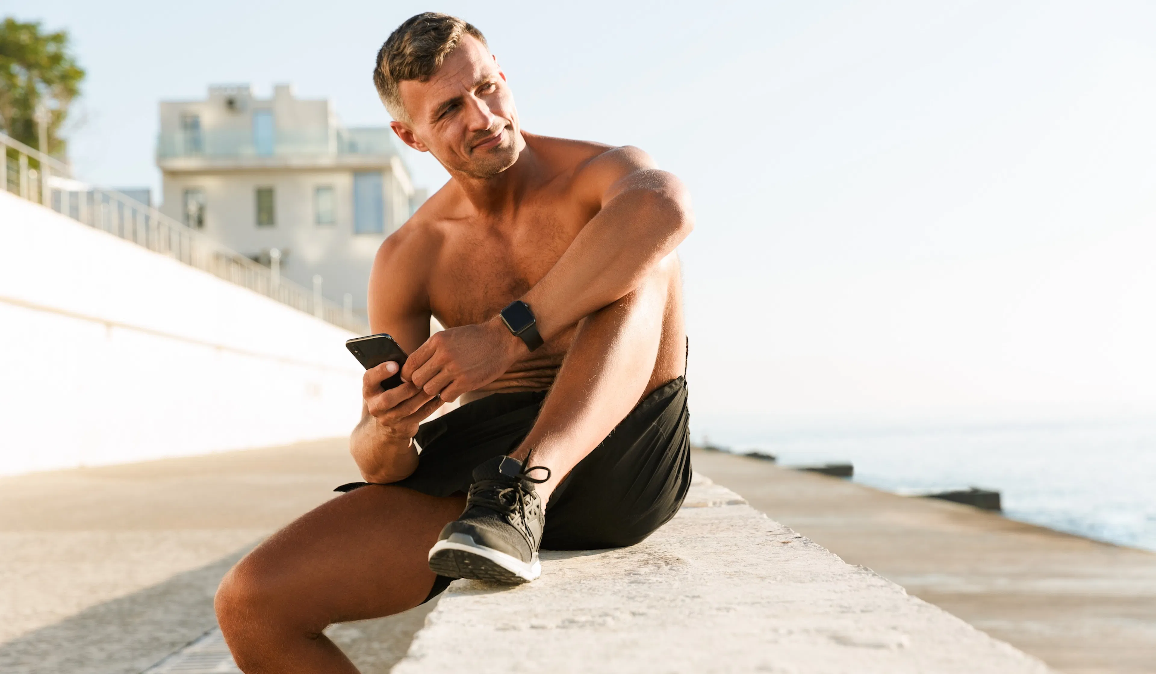Mature sportsman chatting by mobile phone