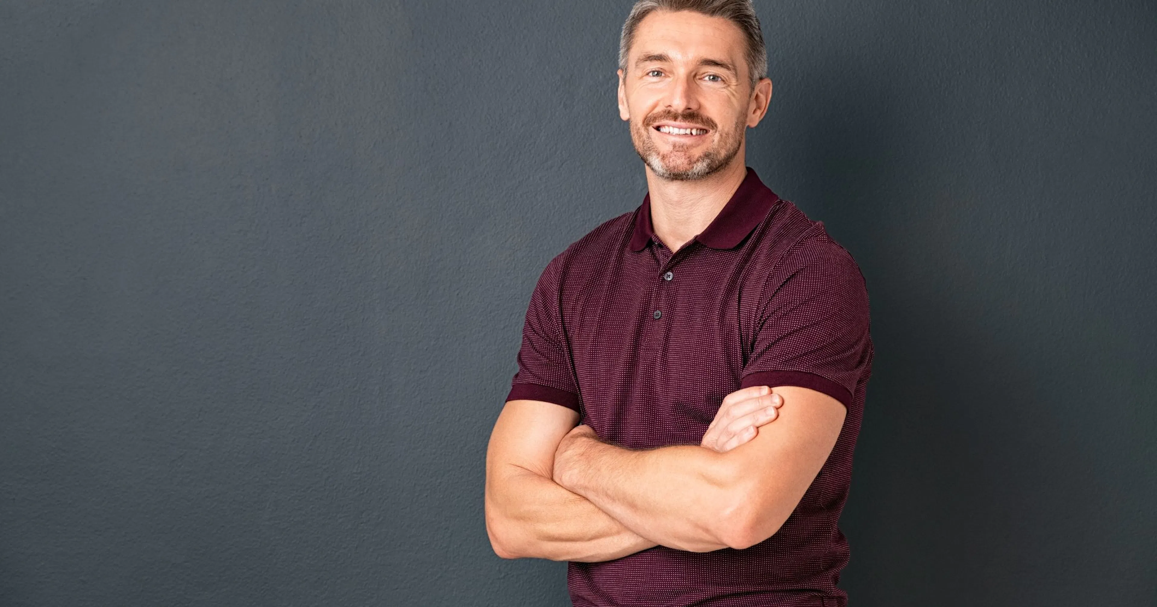 Man smiling in a maroon shirt