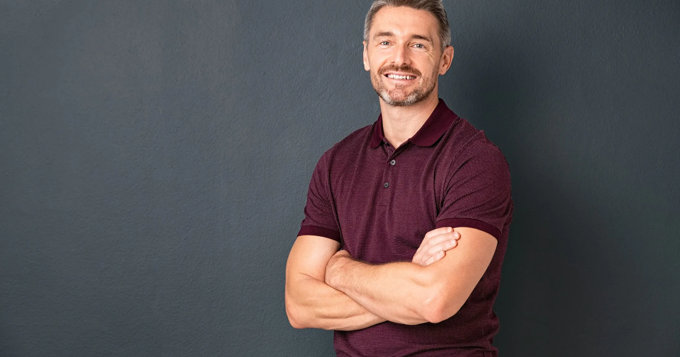 Man smiling in a maroon shirt