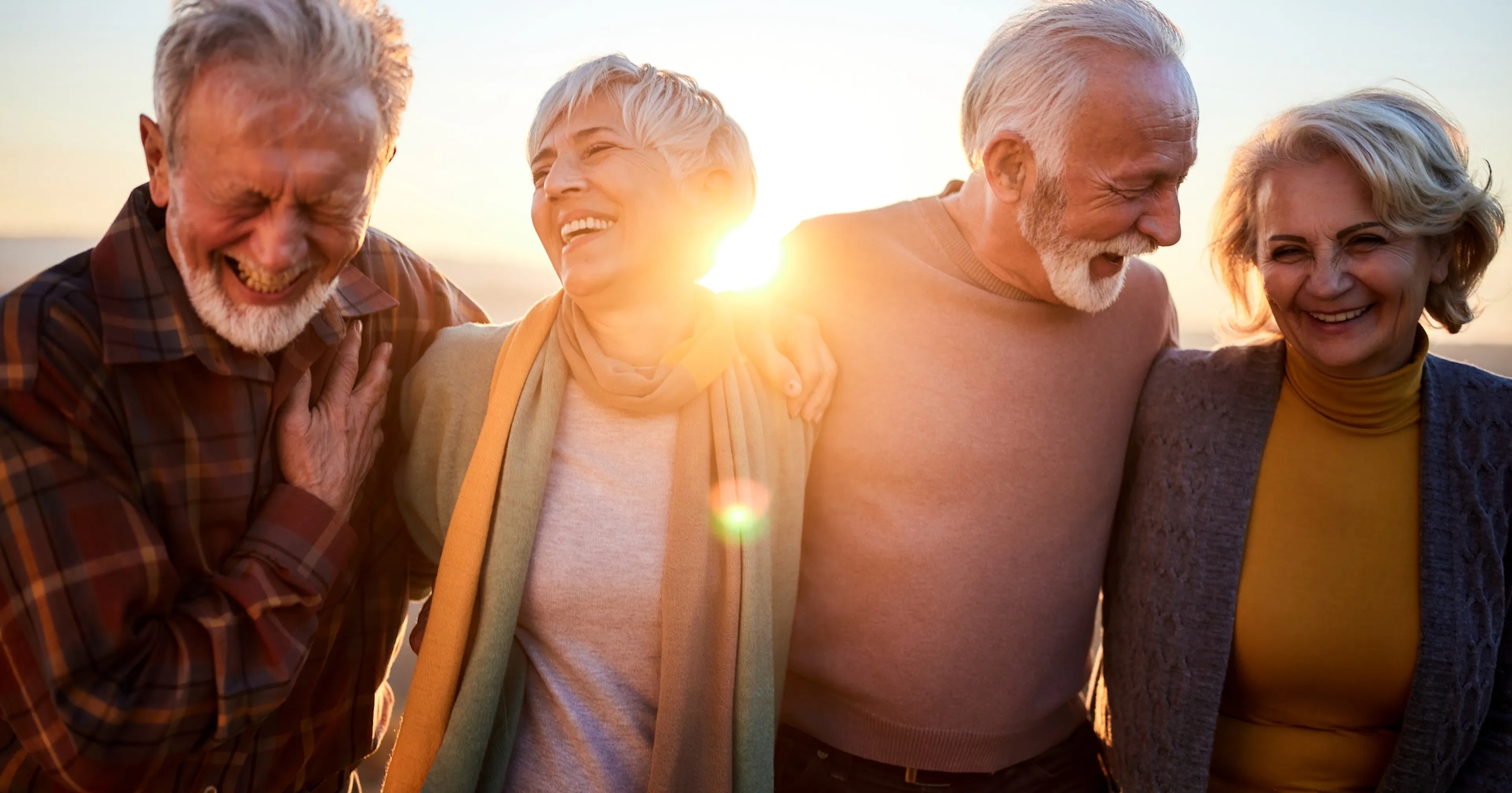 middle age friends walking at sunset