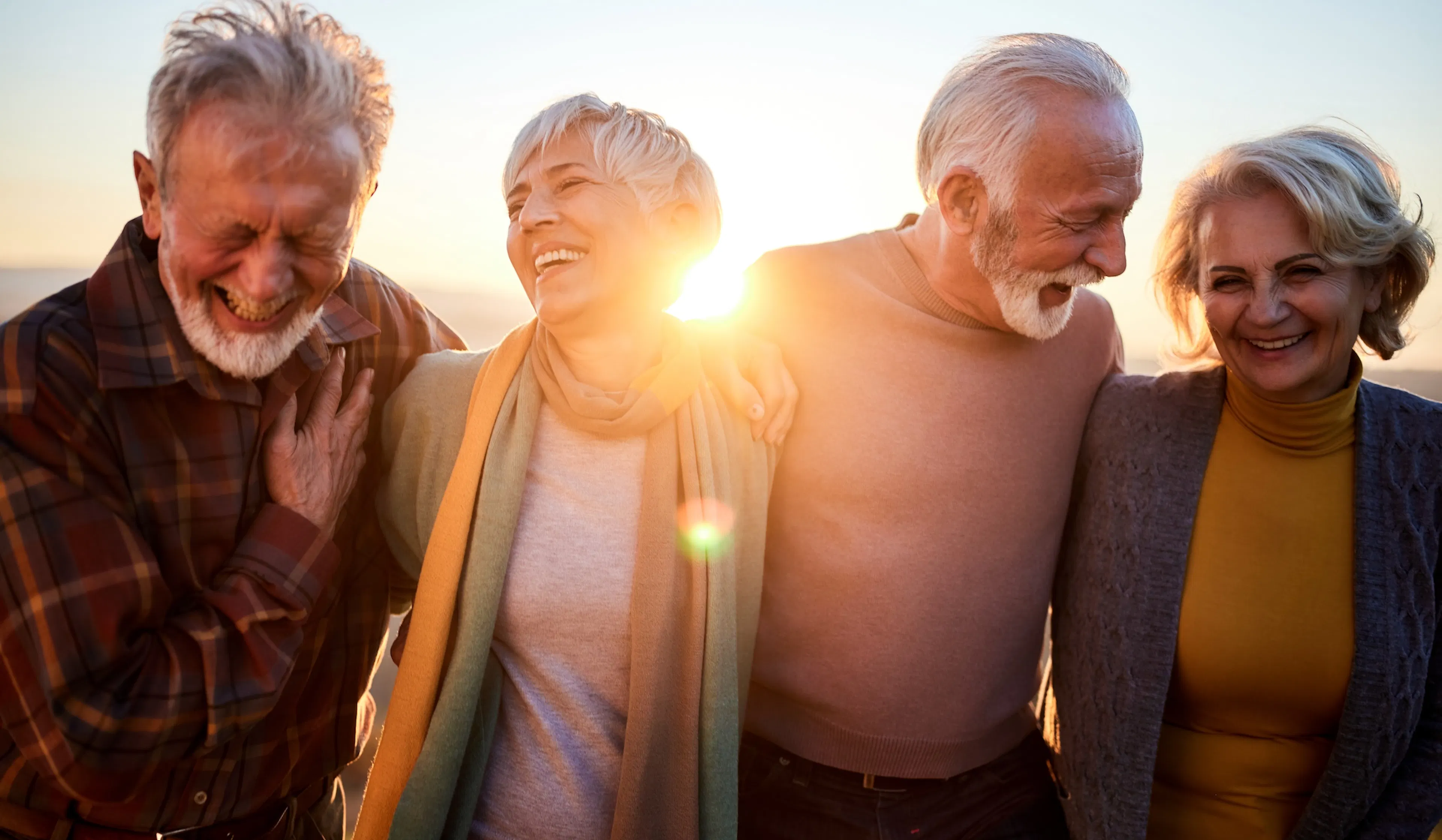 middle age friends walking at sunset