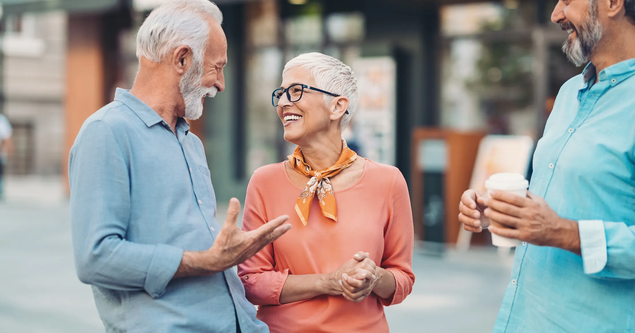 Group of smiling senior friends talking on the street