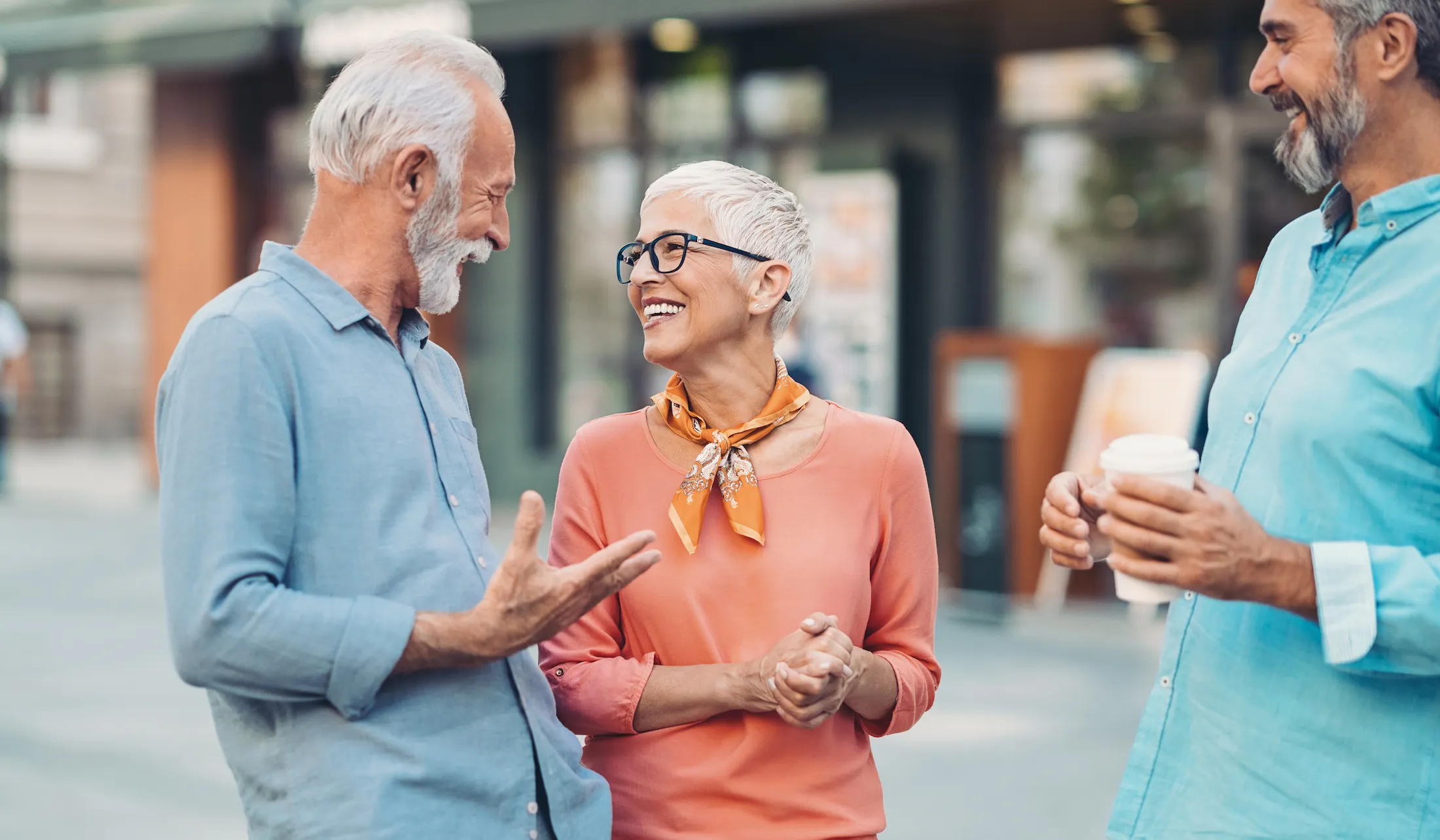 Group of smiling senior friends talking on the street