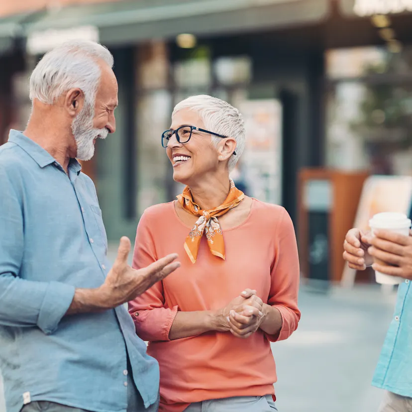 Group of smiling senior friends talking on the street