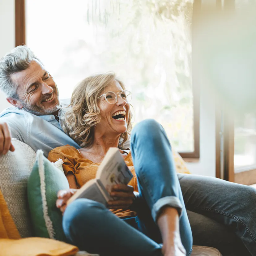 Cheerful mature couple sitting on sofa