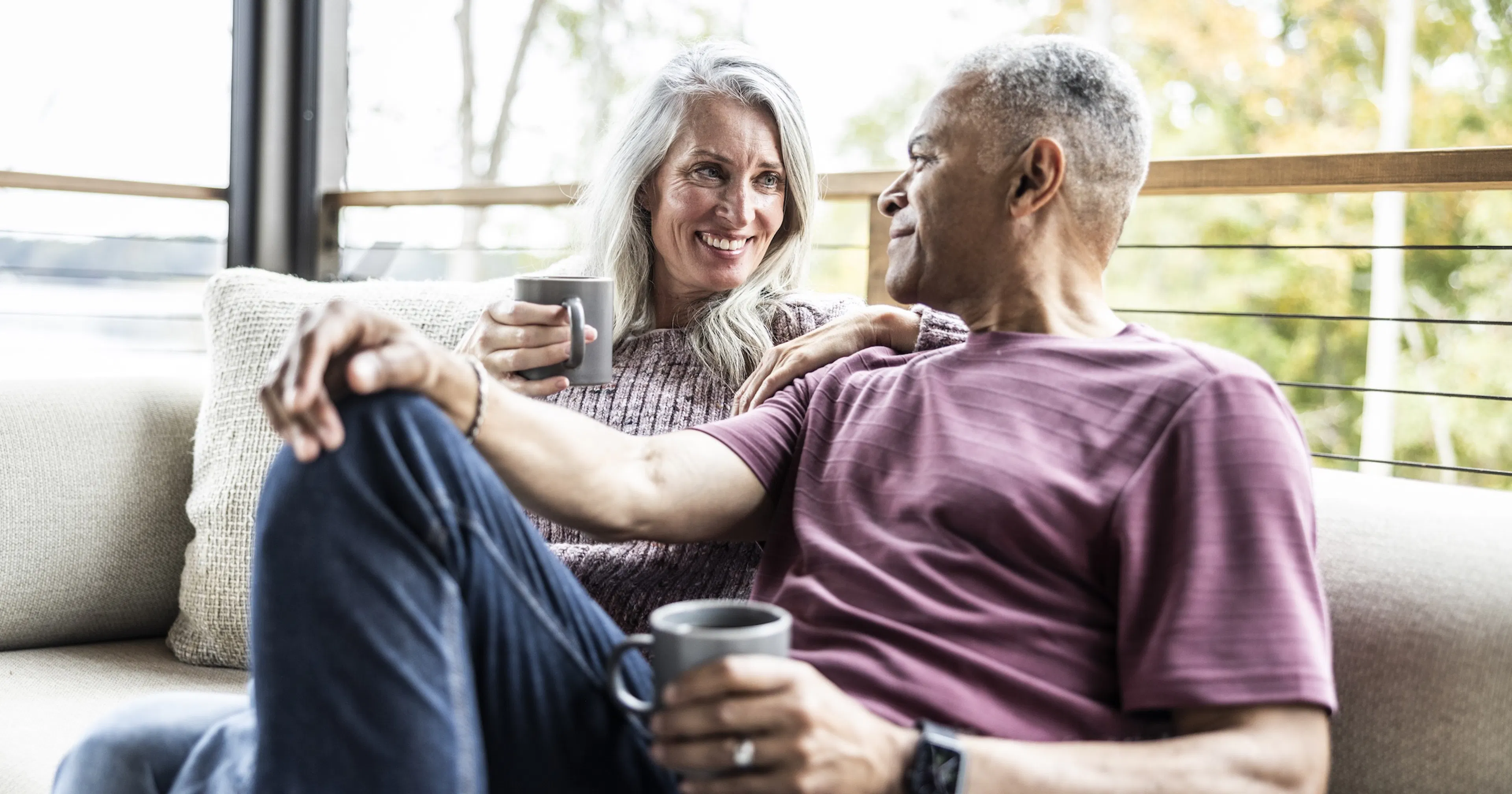 happy middle age couple drinking coffee on a deck