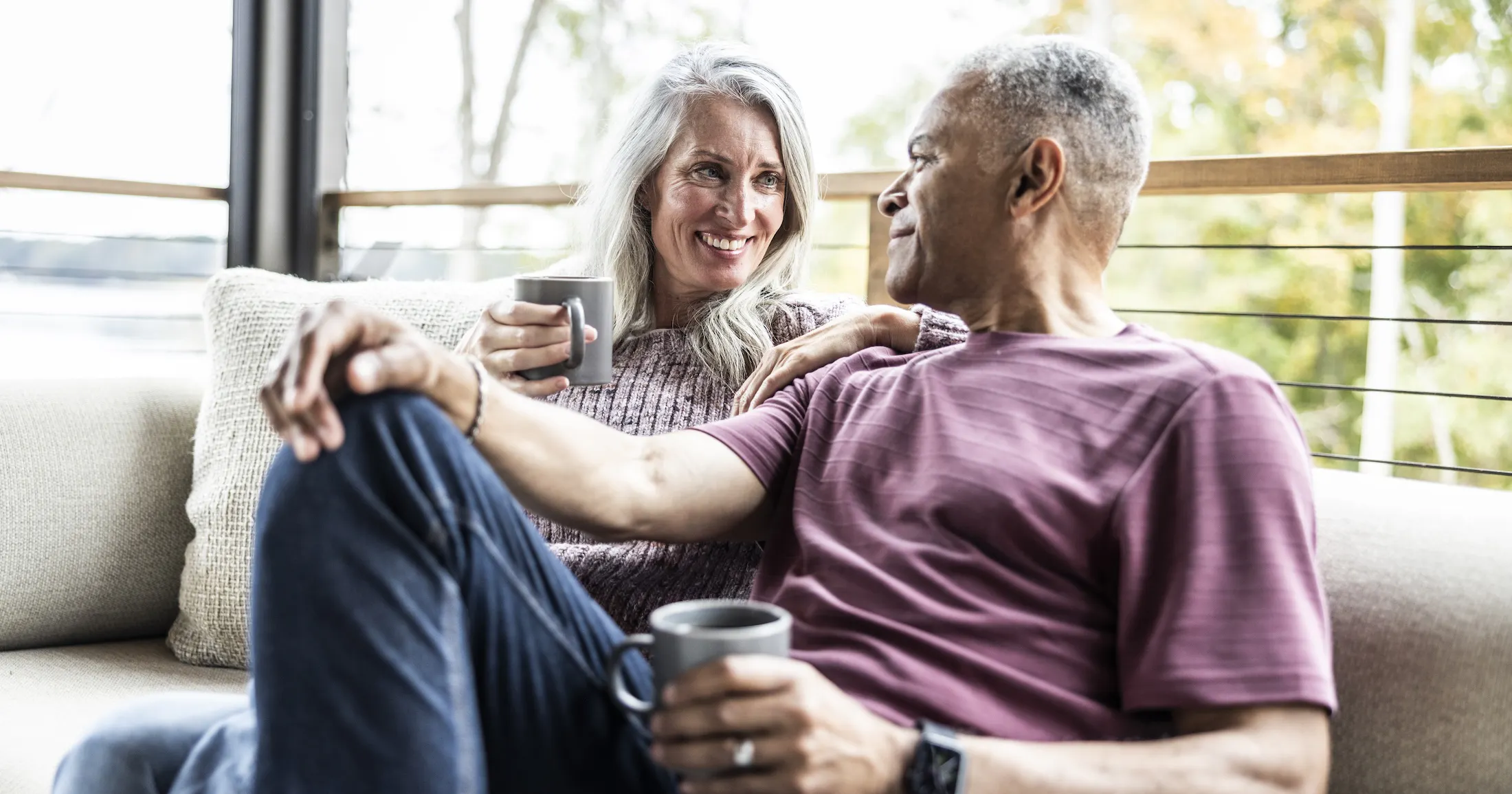 happy middle age couple drinking coffee on a deck