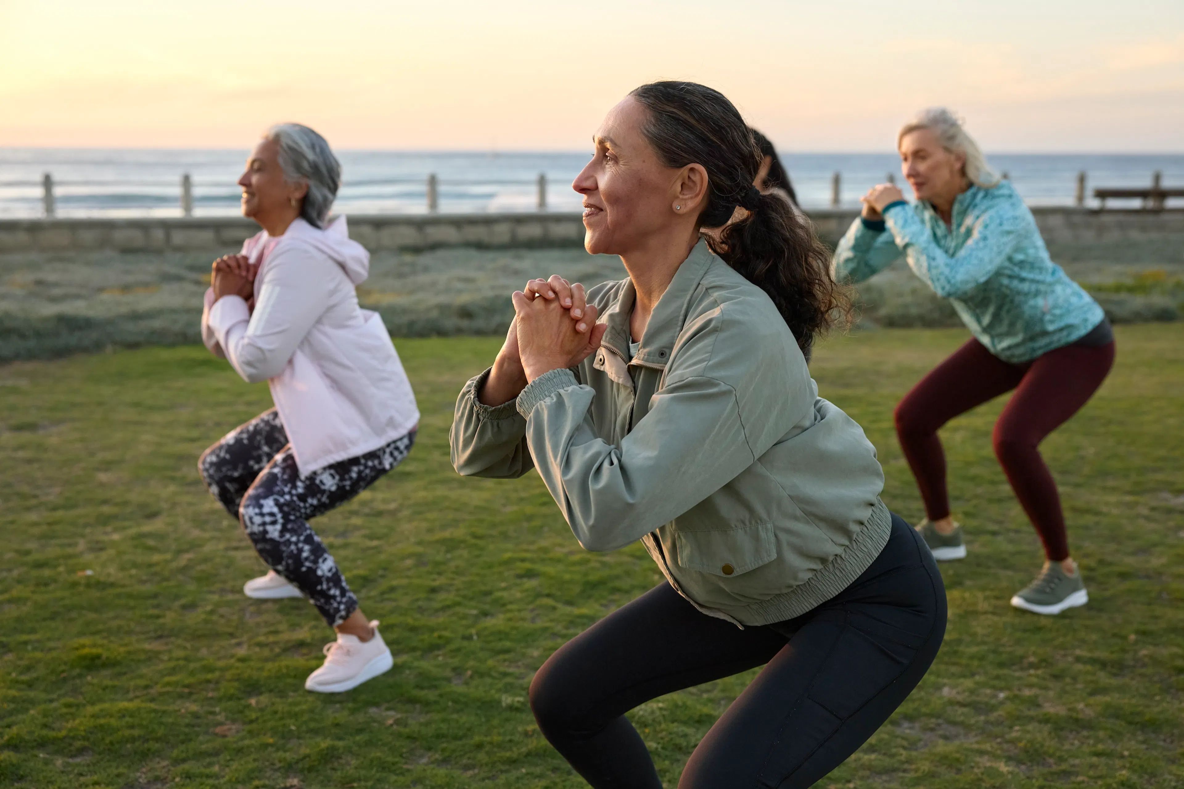 woman squatting while doing exercise with friends