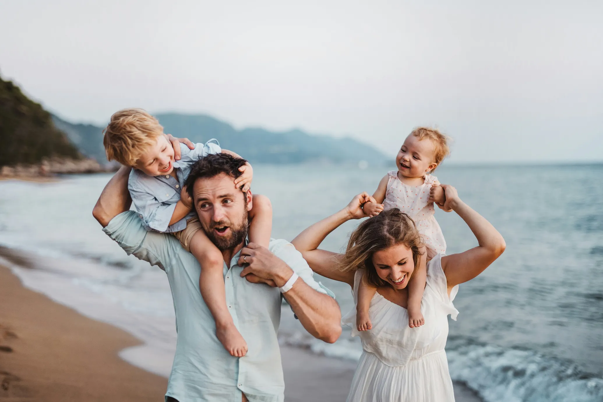 happy parents on the beach with baby and toddler