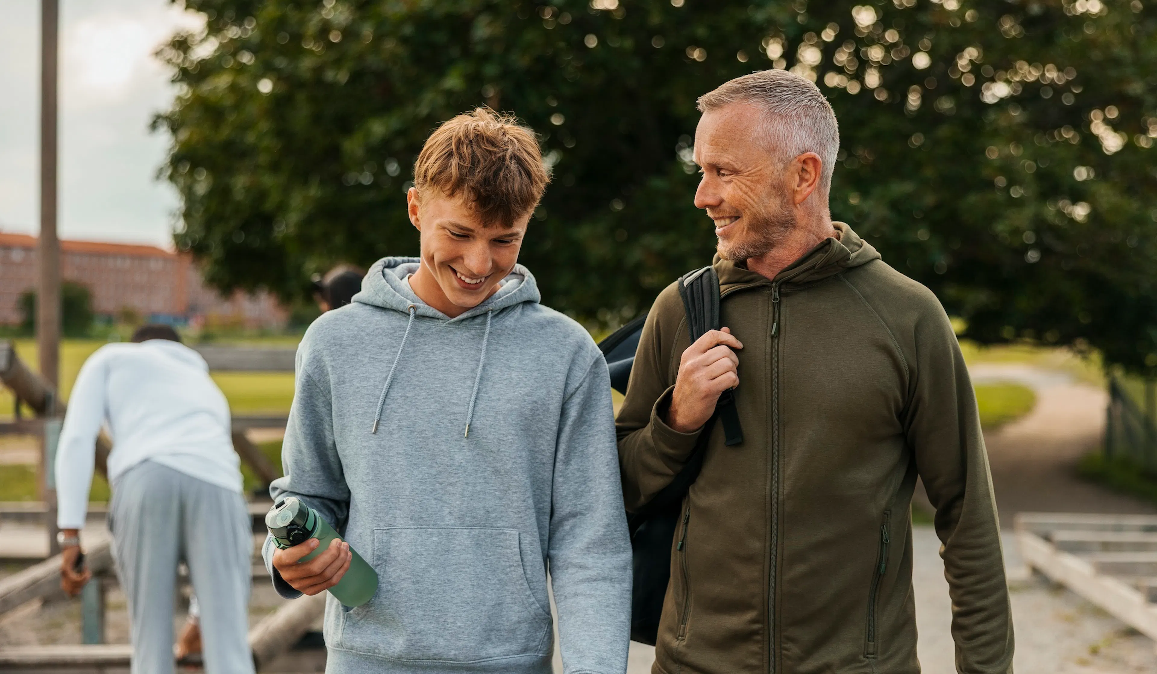 Smiling father and son talking while walking