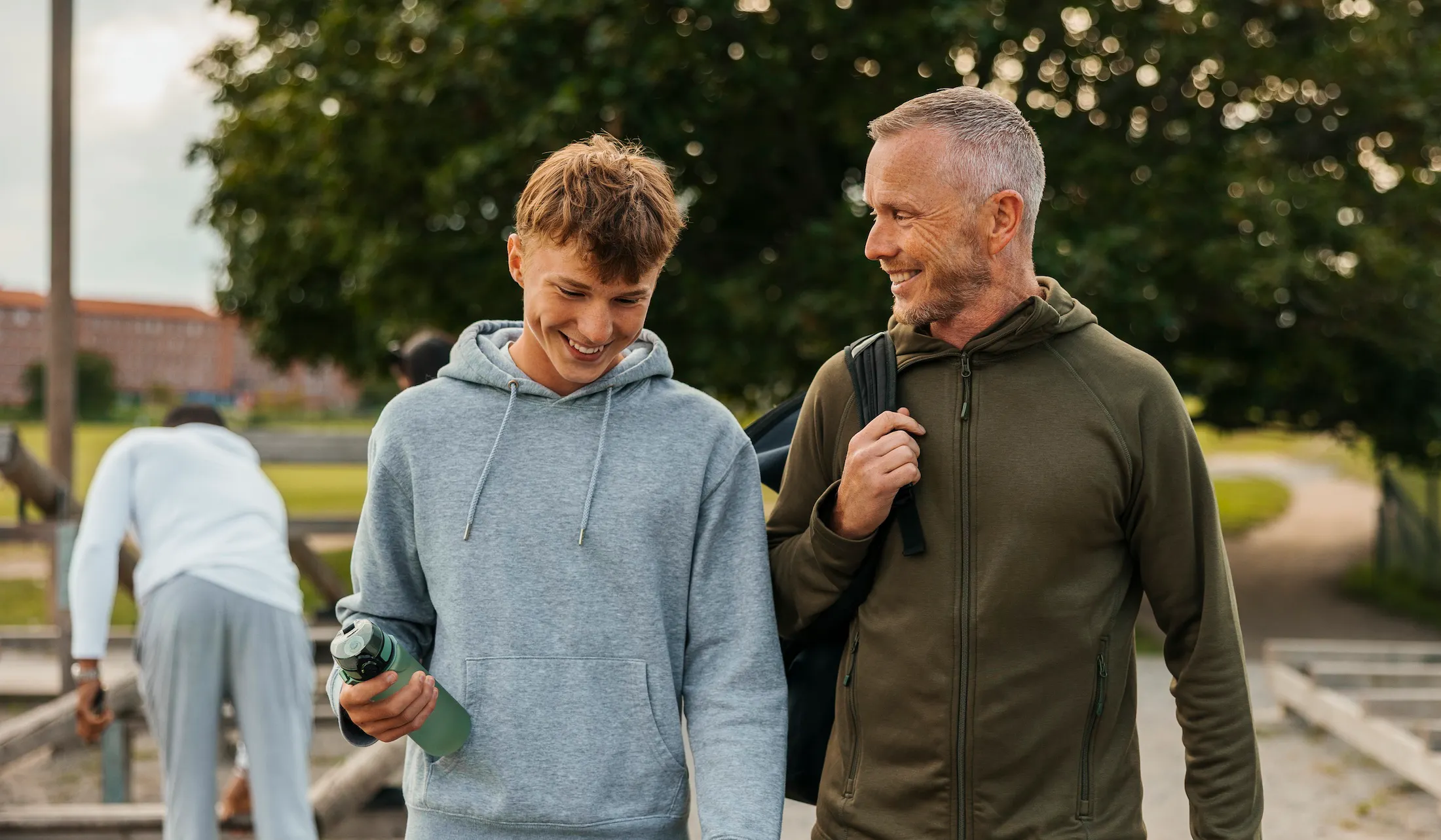 Smiling father and son talking while walking