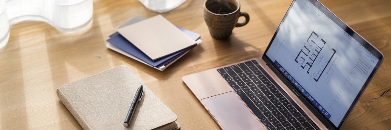 Desk with laptop and norebook