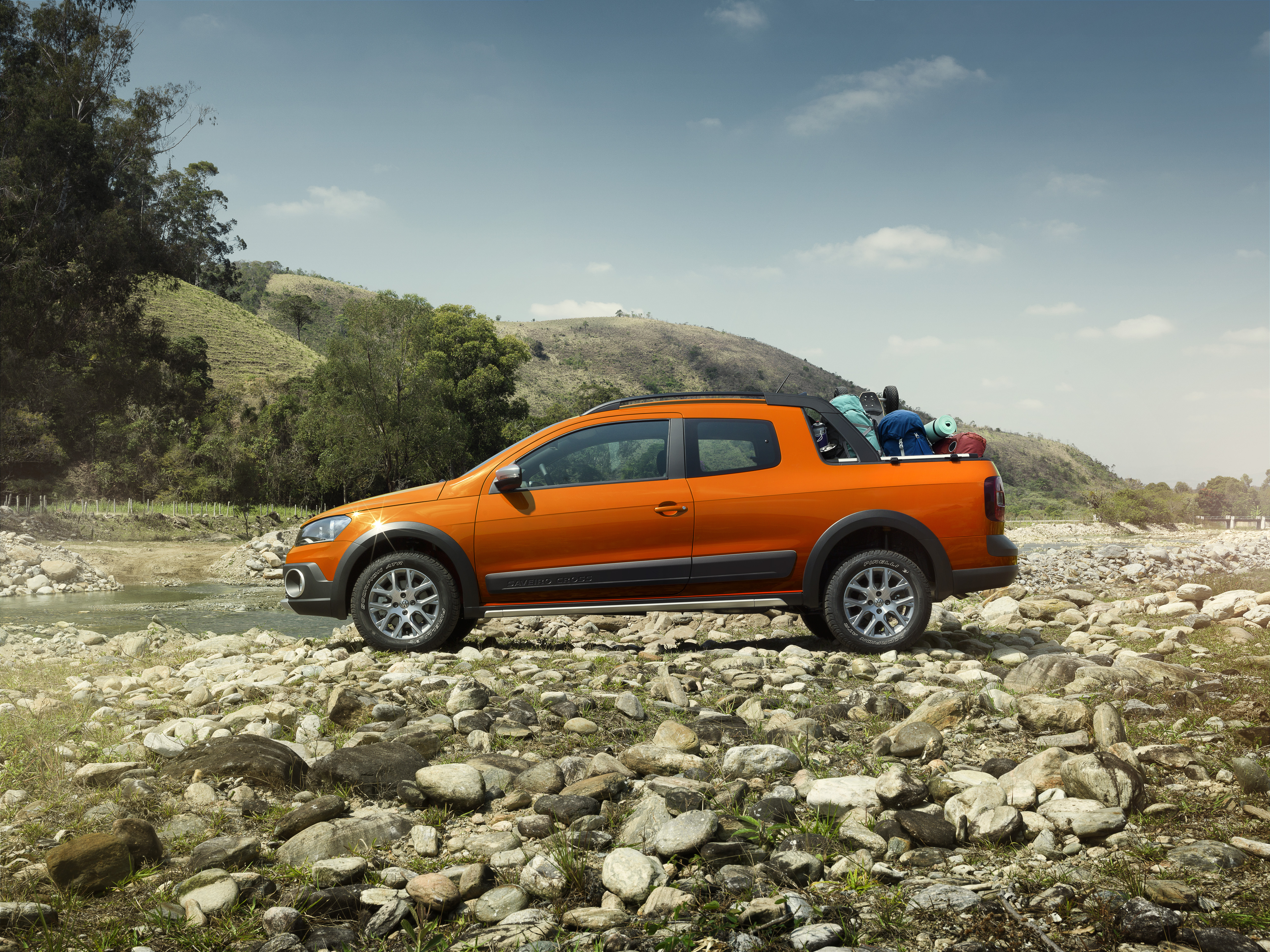Picape Saveiro Laranja em um gramado nas pedra