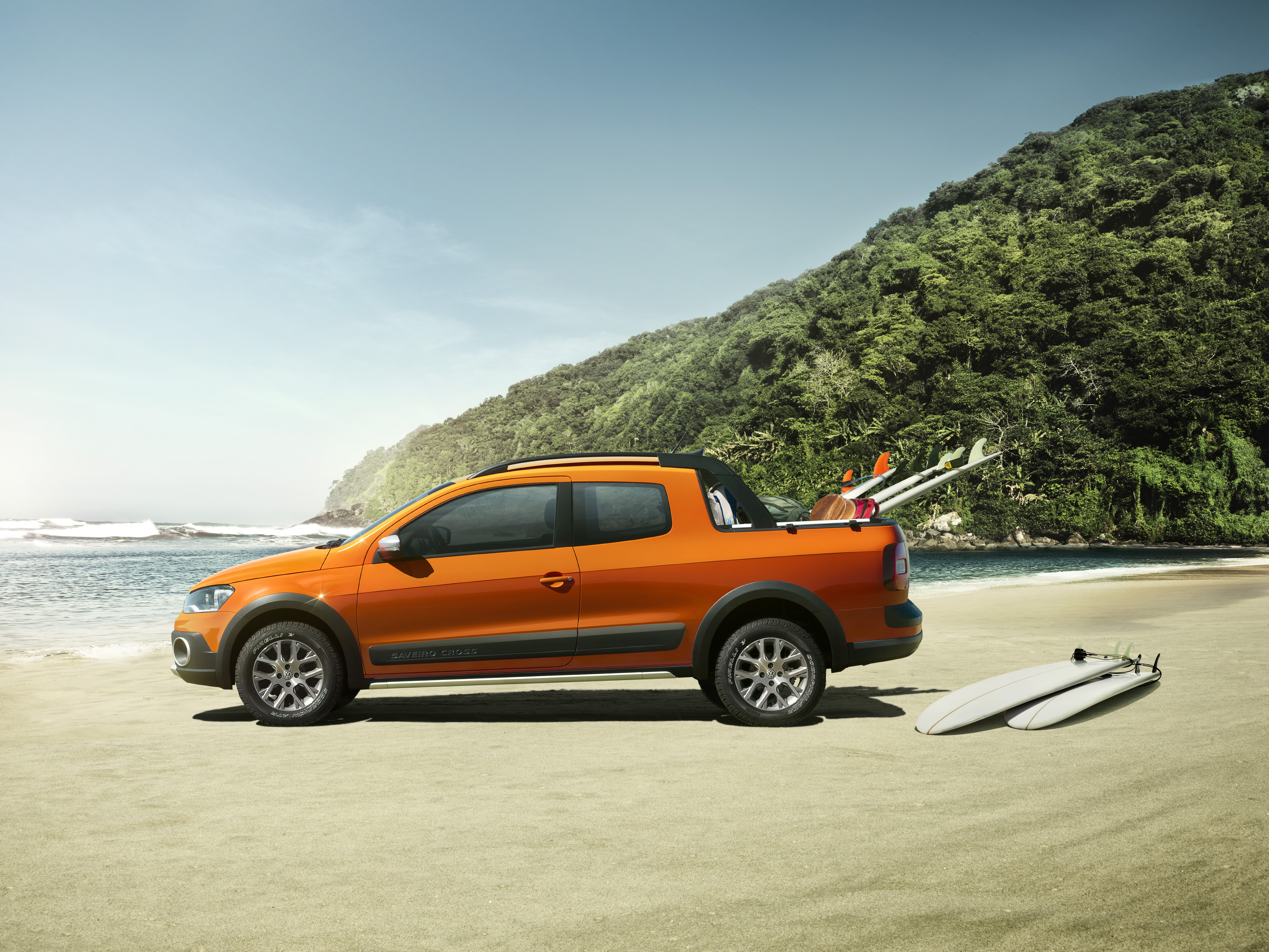 Picape Saveiro Laranja em um gramado na areia de uma praia