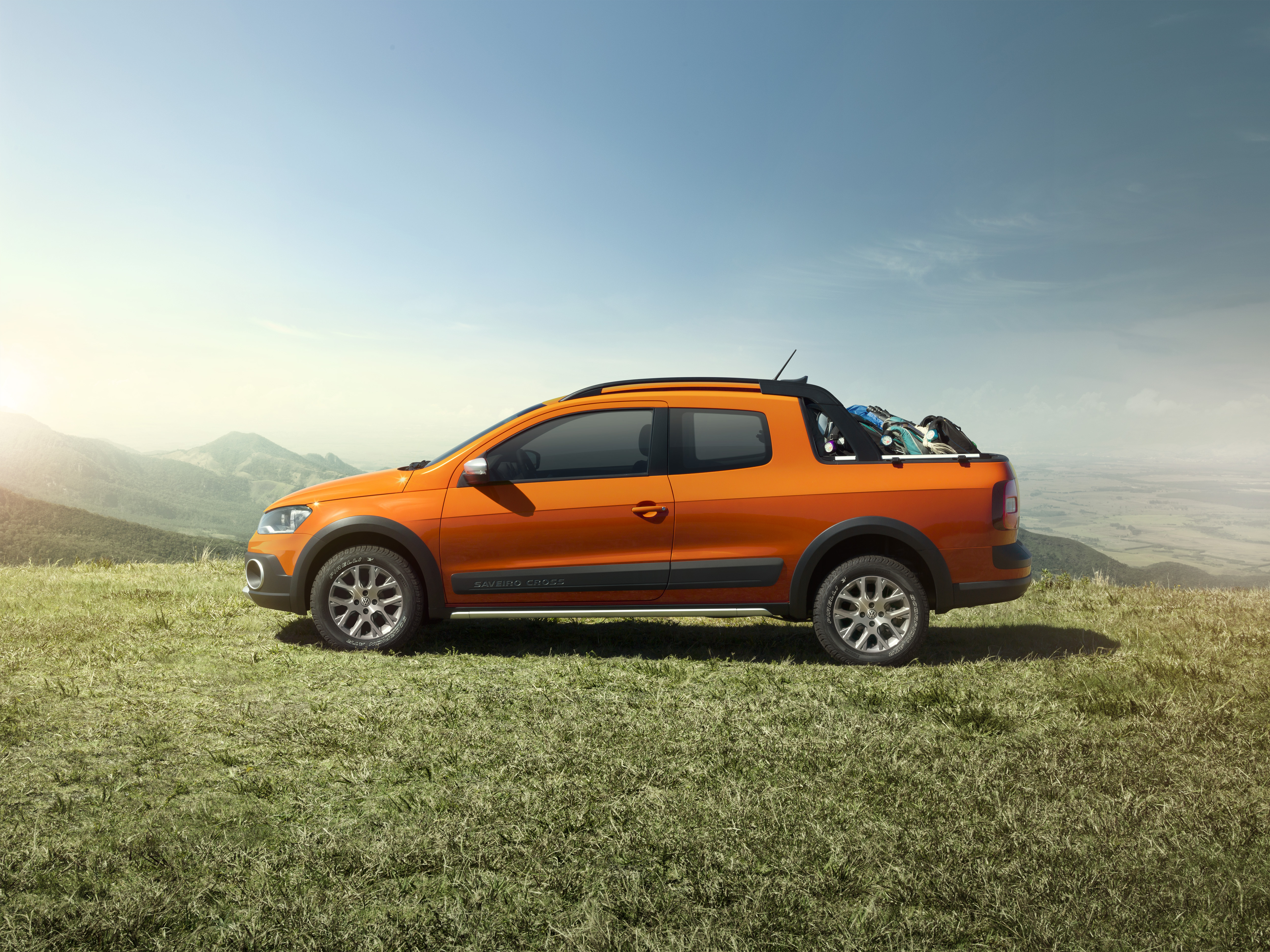 Picape Saveiro Laranja em um gramado nas montanhas