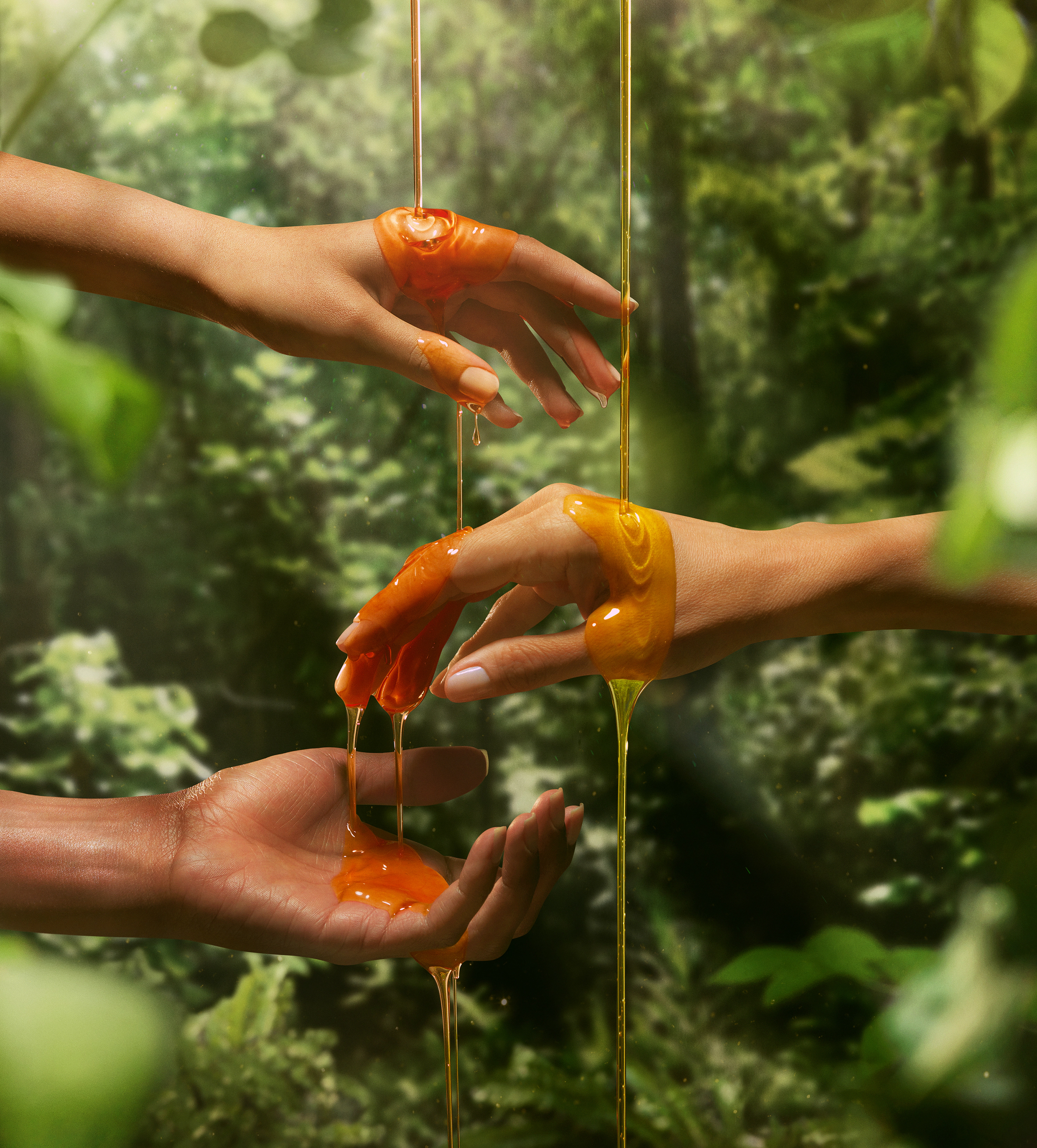 Três braços diferentes na floresta com sabonete Natura Ekos sendo despejado nas mãos