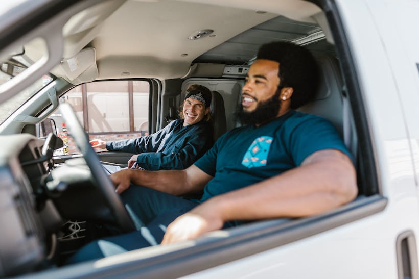 Movers in delivery truck smiling