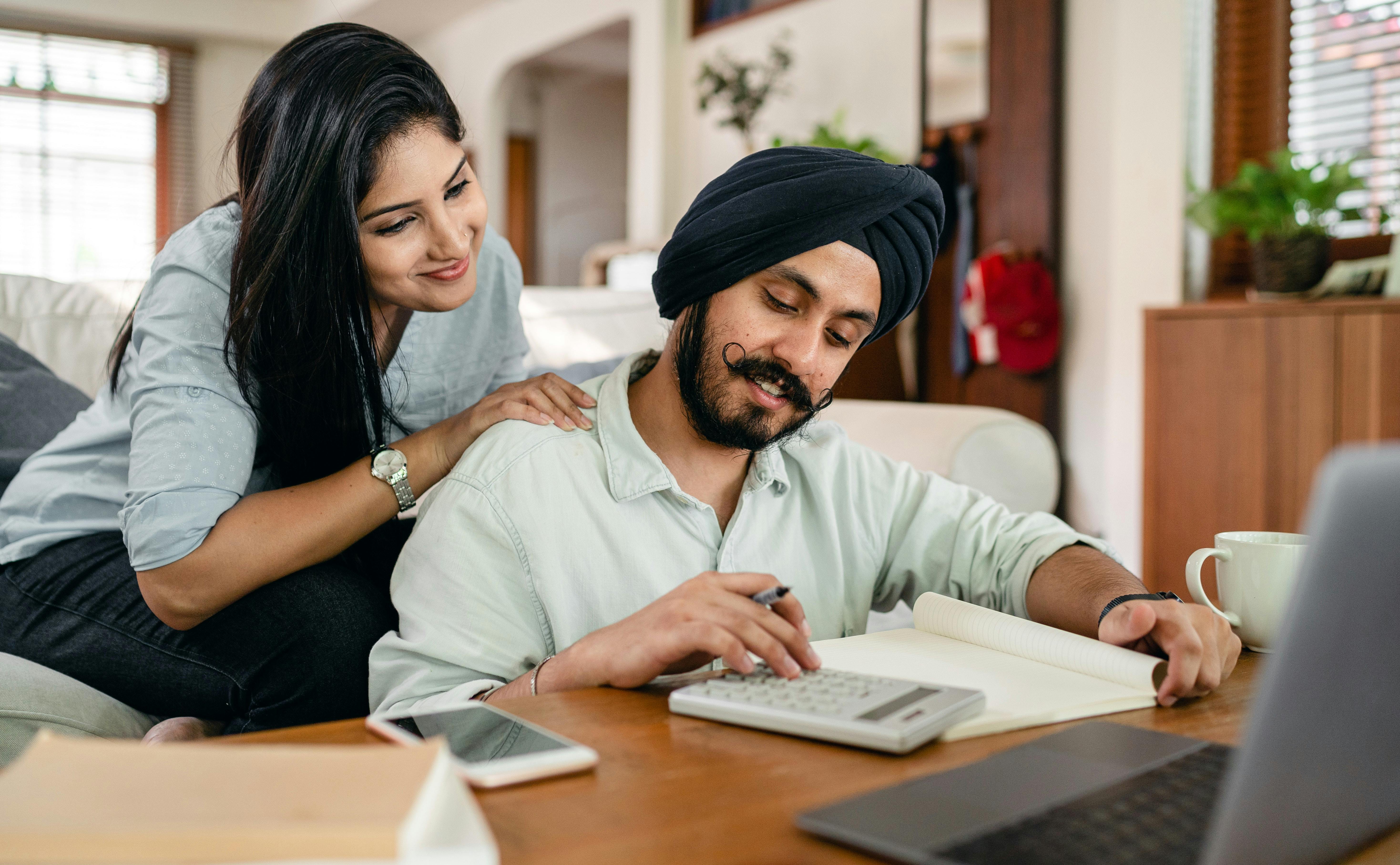 Couple doing calculations with calculator