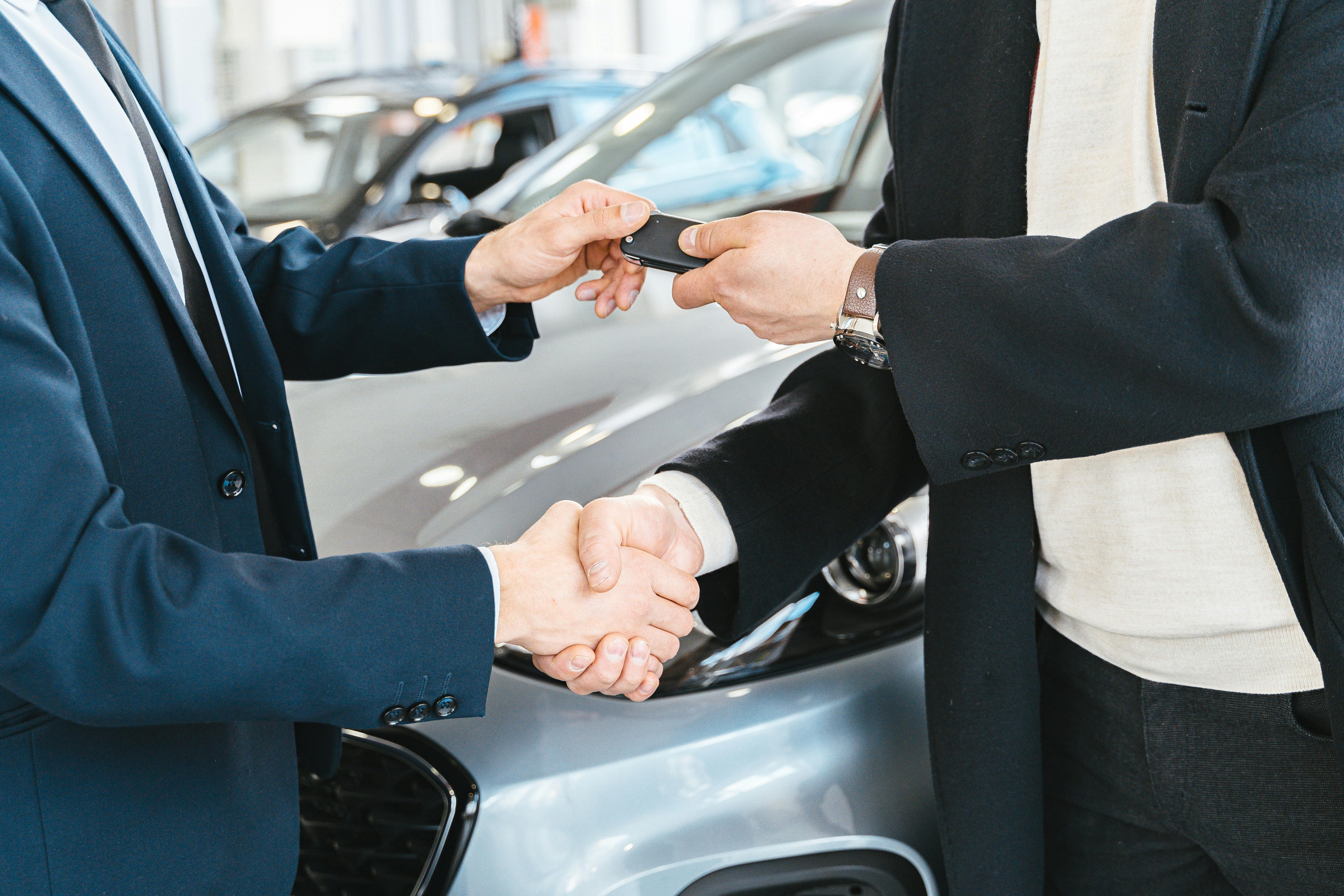 Men shaking hands and exchanging car key