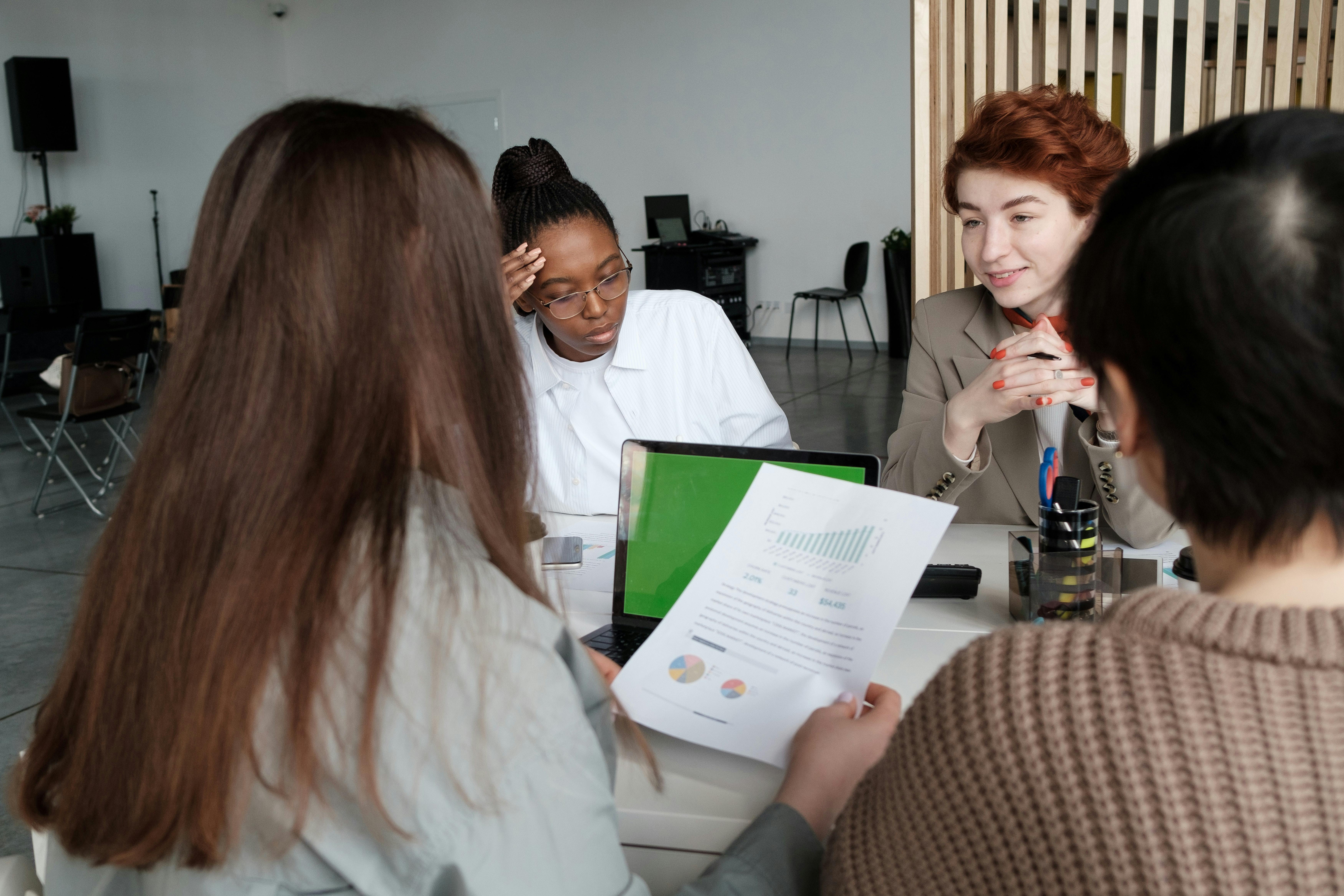 Women in bank applying for loan and reviewing financial documents