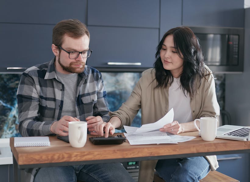 Couple discussing finances at kitchen table