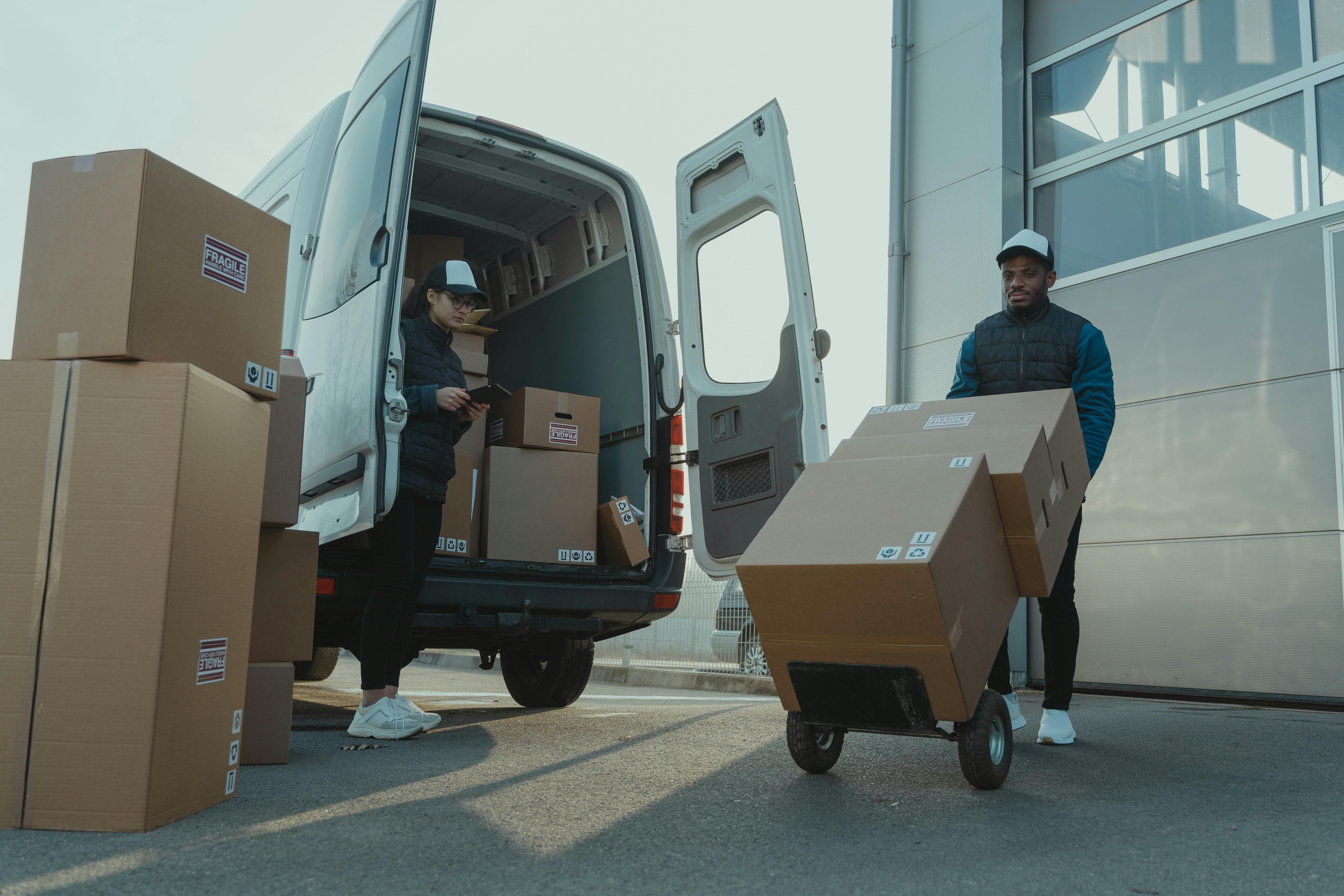 Man and woman making delivering boxes with van 