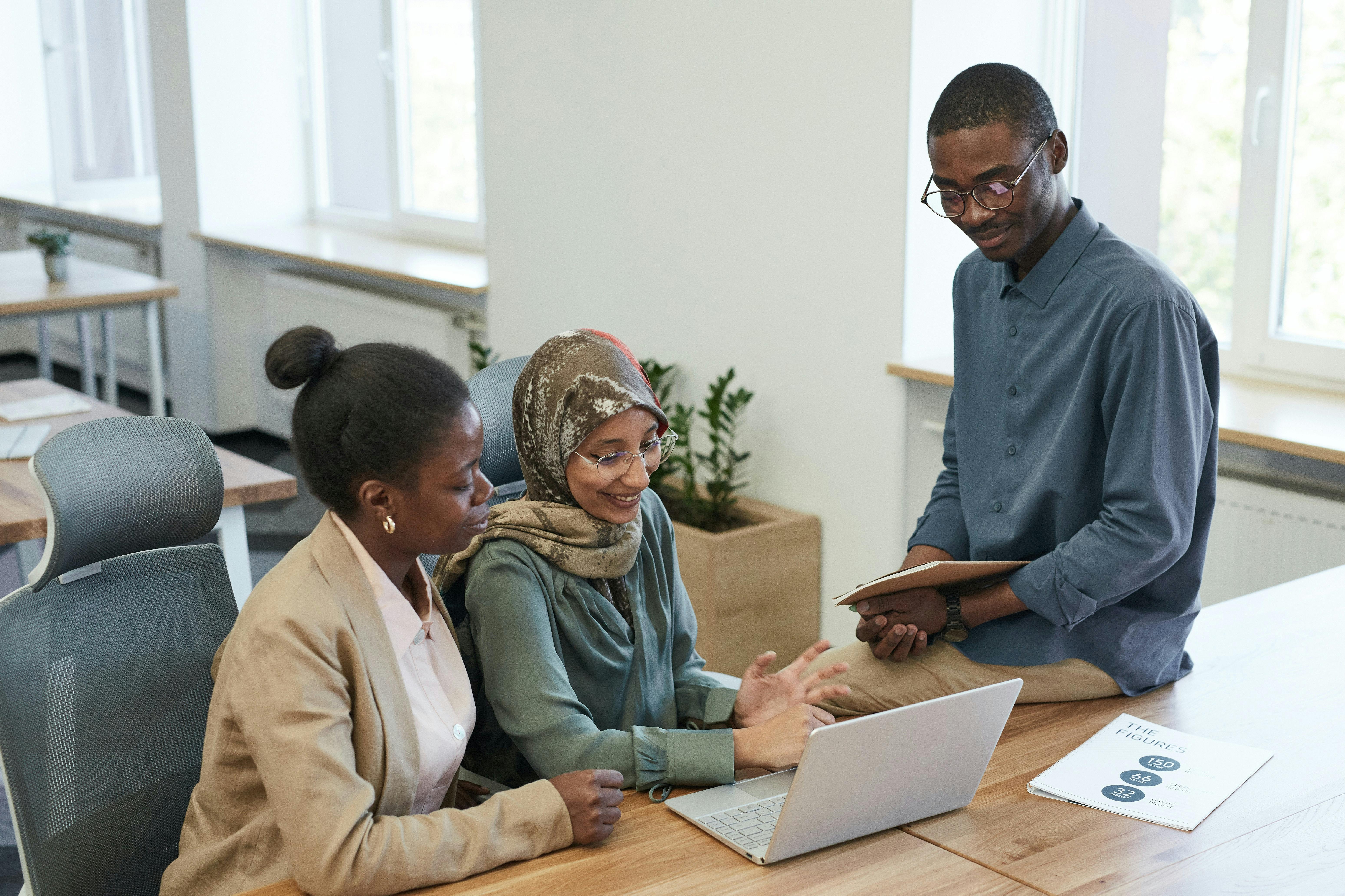 Coworkers sitting at desk and looking at computer