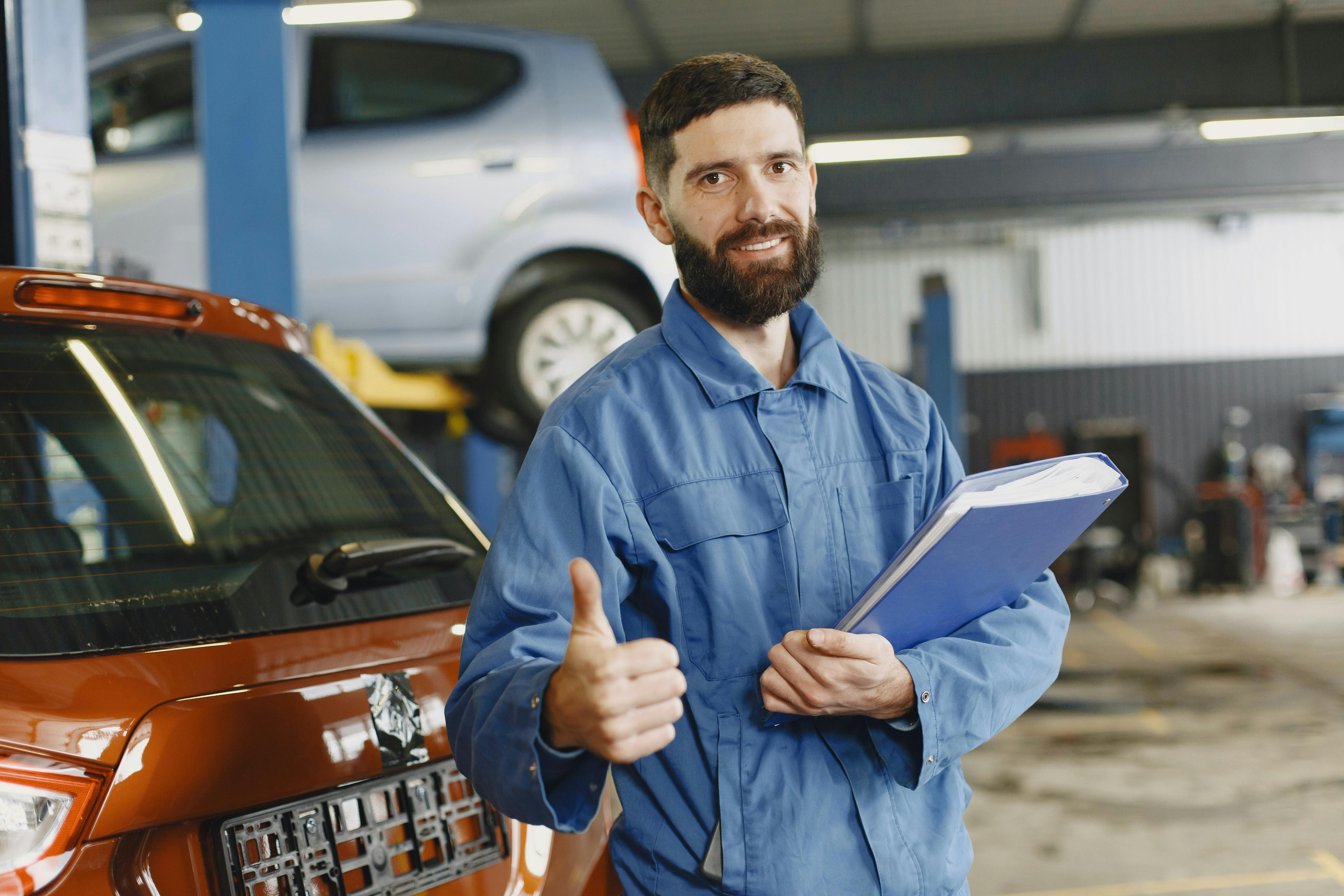 Car mechanic in shop giving thumbs up