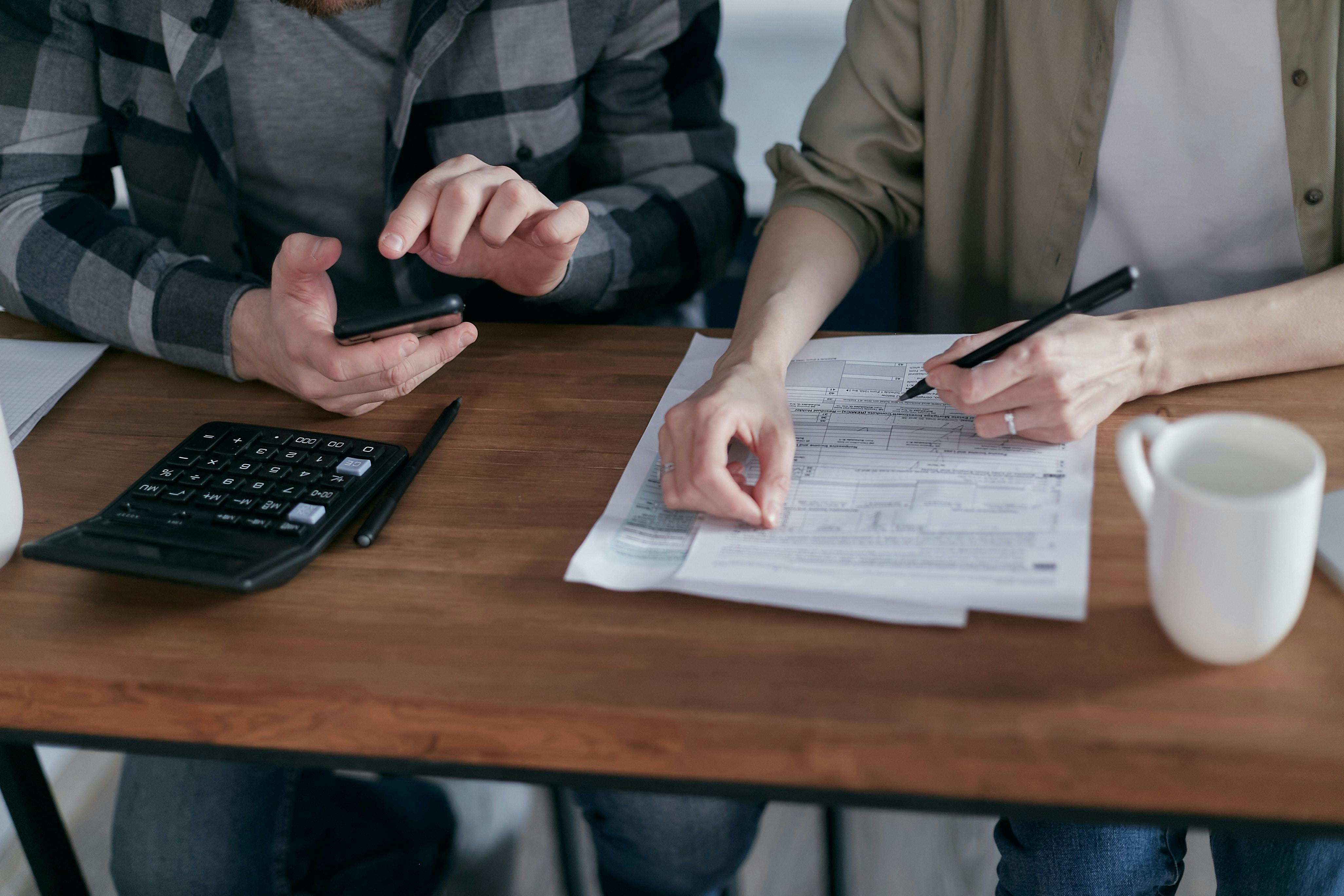 Man and woman at desk with calculator and loan application