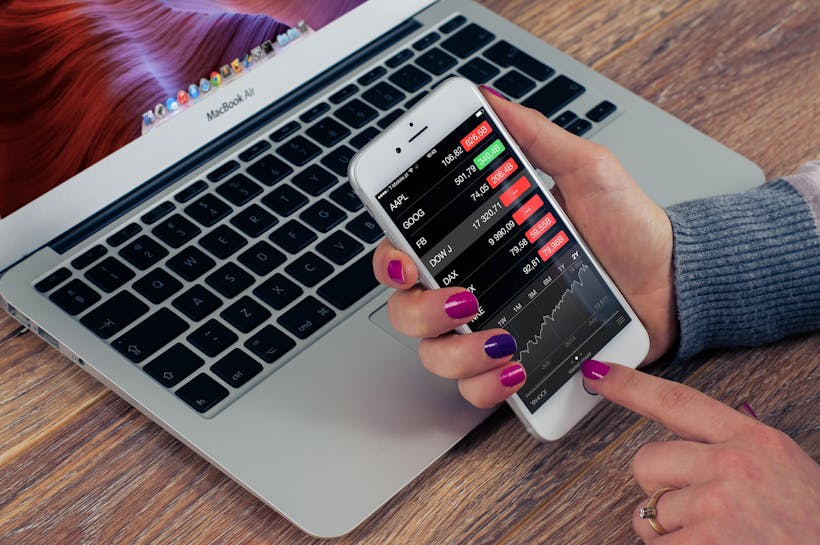 Hands holding smartphone checking stock portfolio